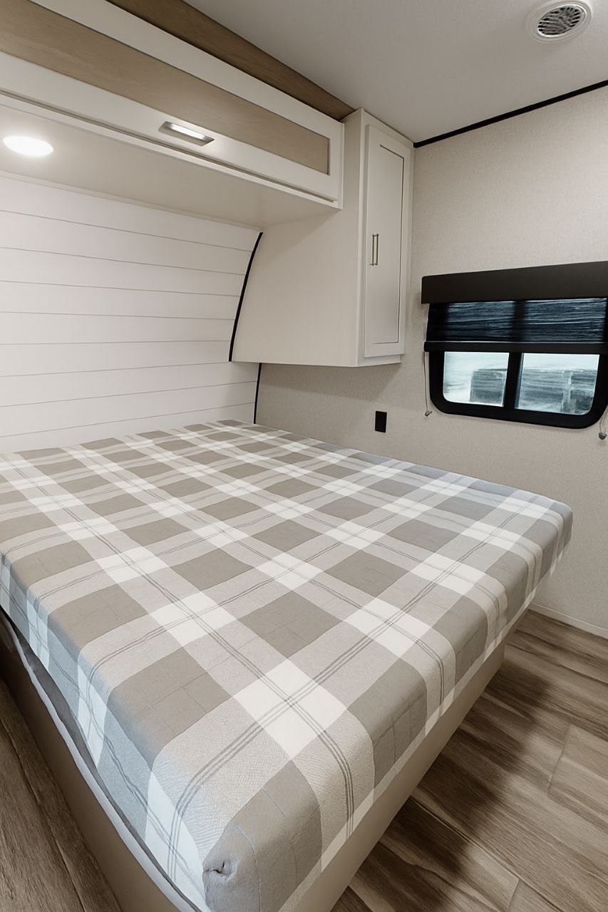 Cozy RV rental bedroom with plaid bed, overhead storage, and modern interior.. jayco JAY FLIGHT SLX 263BHSW 2025