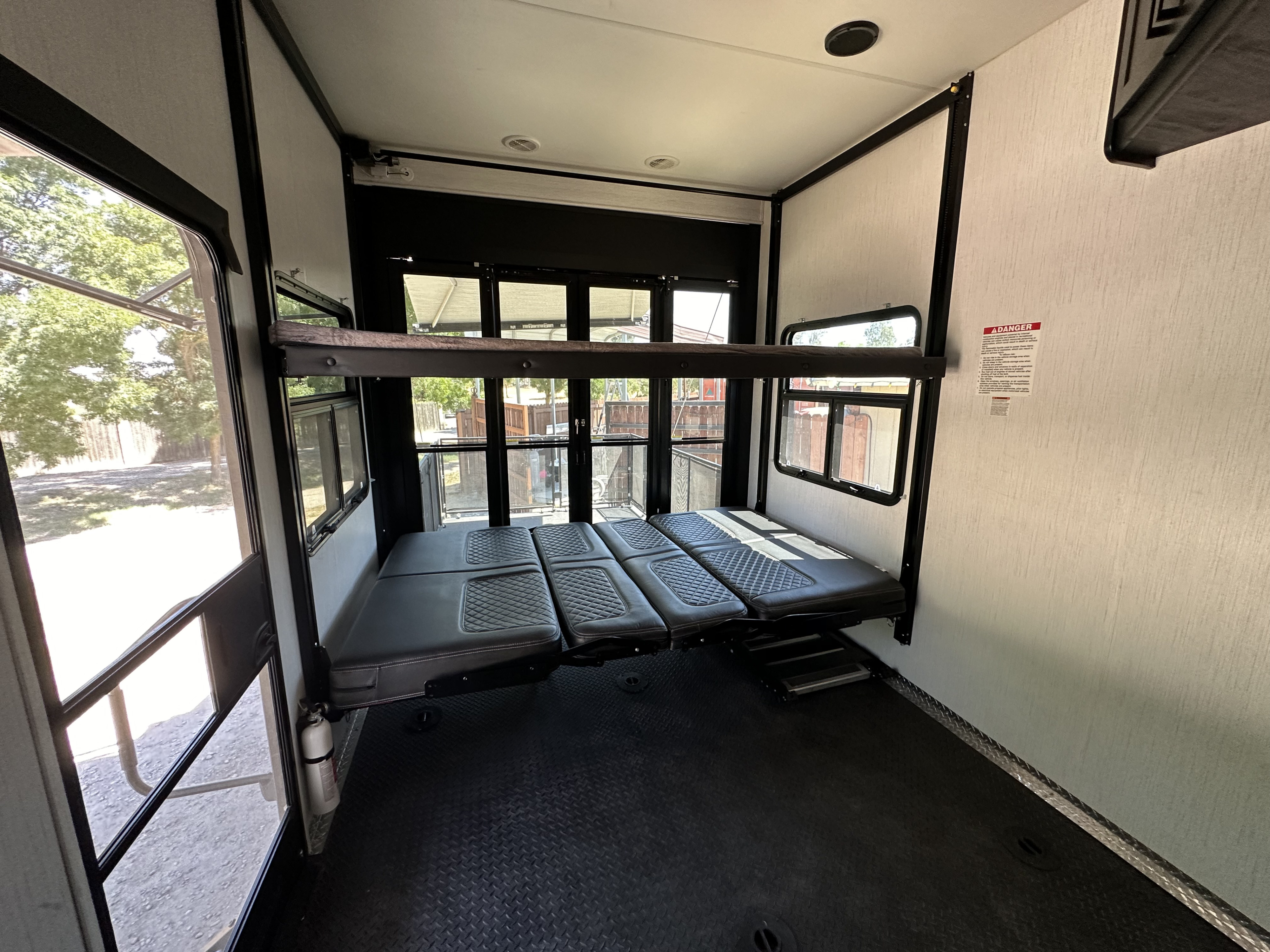 RV rental toy hauler interior: convertible bunk beds, durable diamond plate floor, and spacious garage area.. Heartland RVs Road Warrior Toy Hauler 2022