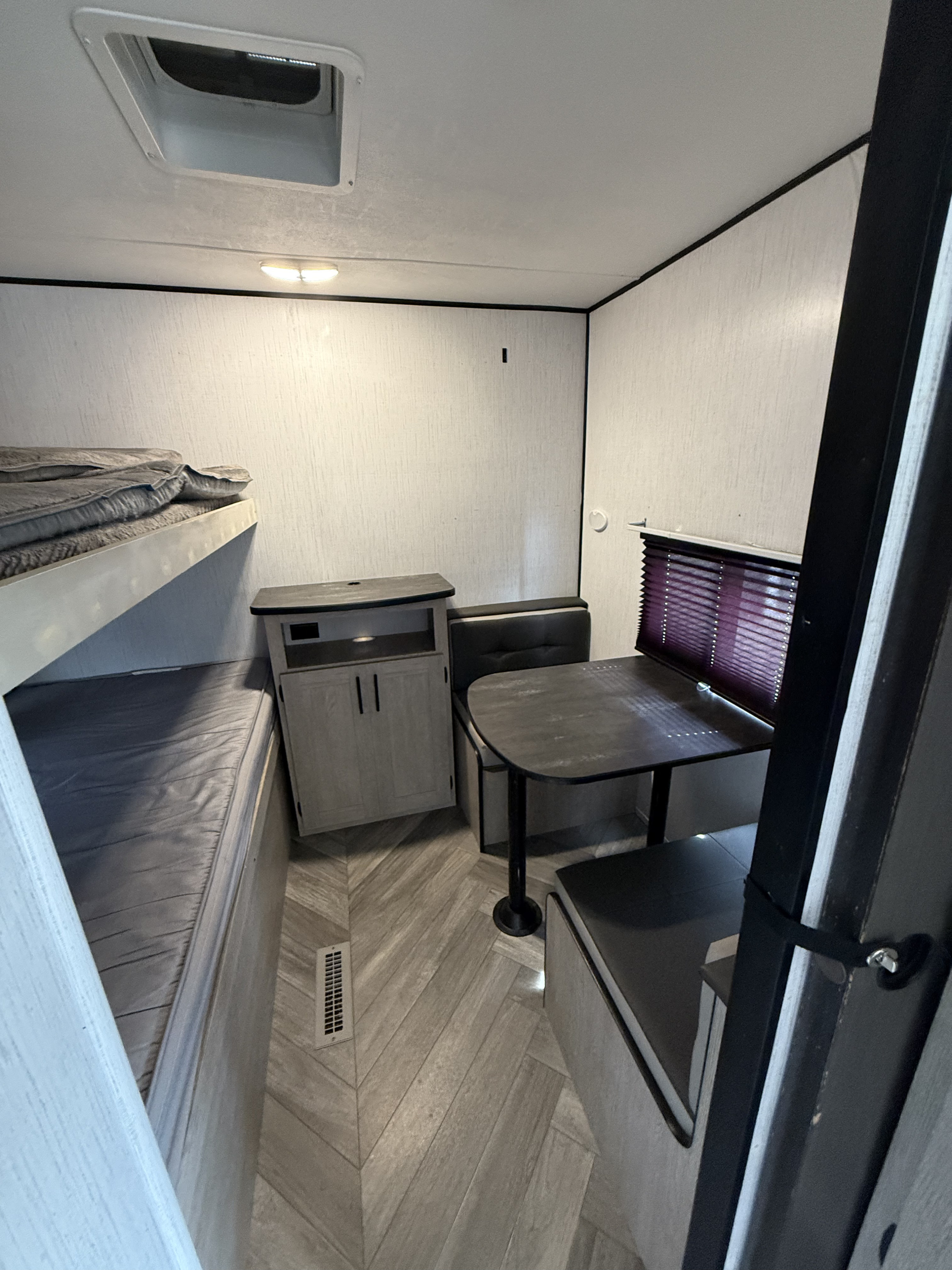 Compact rv rental interior with bunk beds, a dinette with table, and storage, maximizing space for comfortable travel.. Heartland RVs Prowler 2021