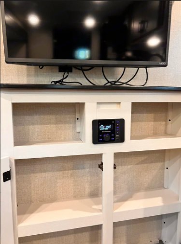 RV rental entertainment: Wall-mounted TV, built-in stereo, and open storage in the living area.. Starcraft Autumn Ridge 2024
