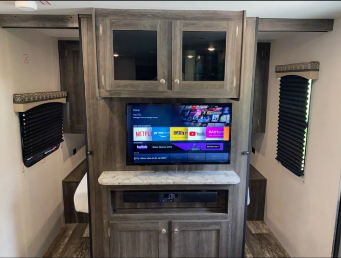 Spacious RV rental interior with entertainment center, smart TV, and comfortable bunk beds. Perfect for family trips.. Starcraft Autumn Ridge 2020