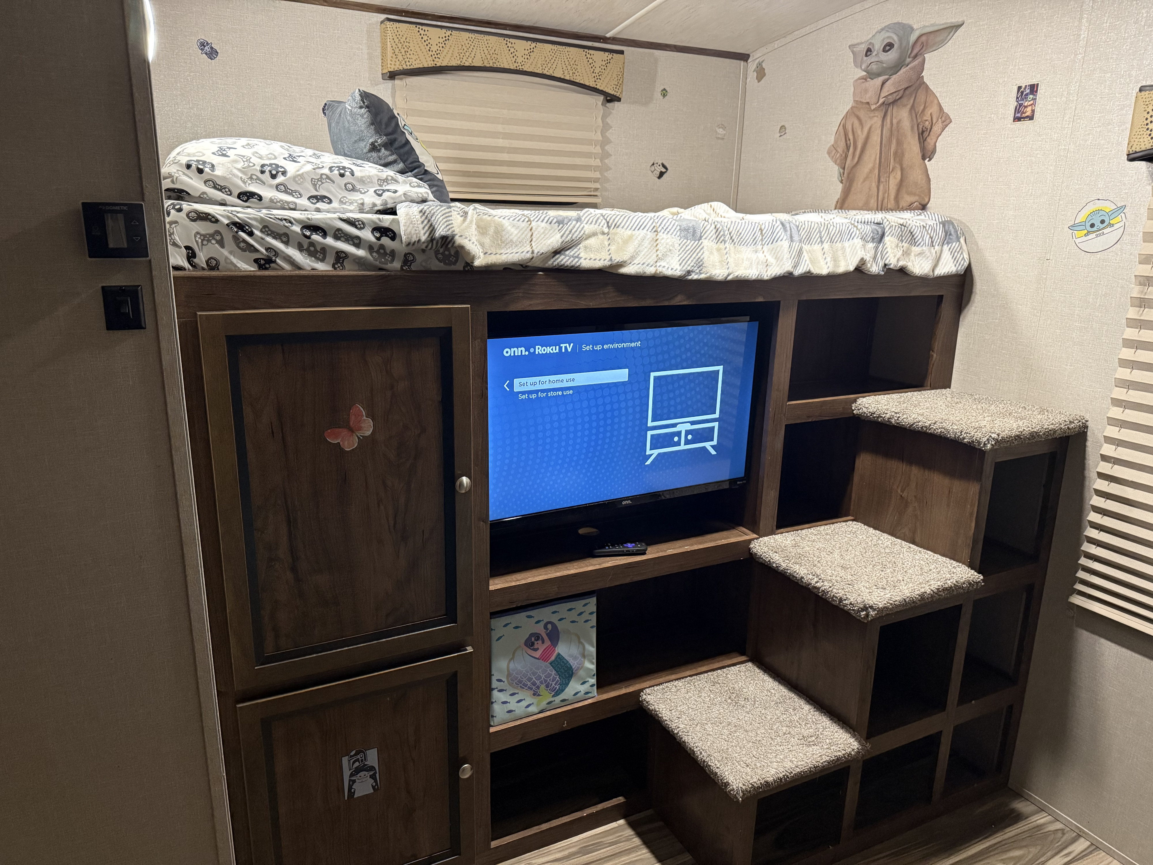 Inside a fun RV rental: a bunk bed with gamer sheets, Grogu decor, a Roku TV, and carpeted storage steps.. Cruiser RV MPG Ultra Lite 2018