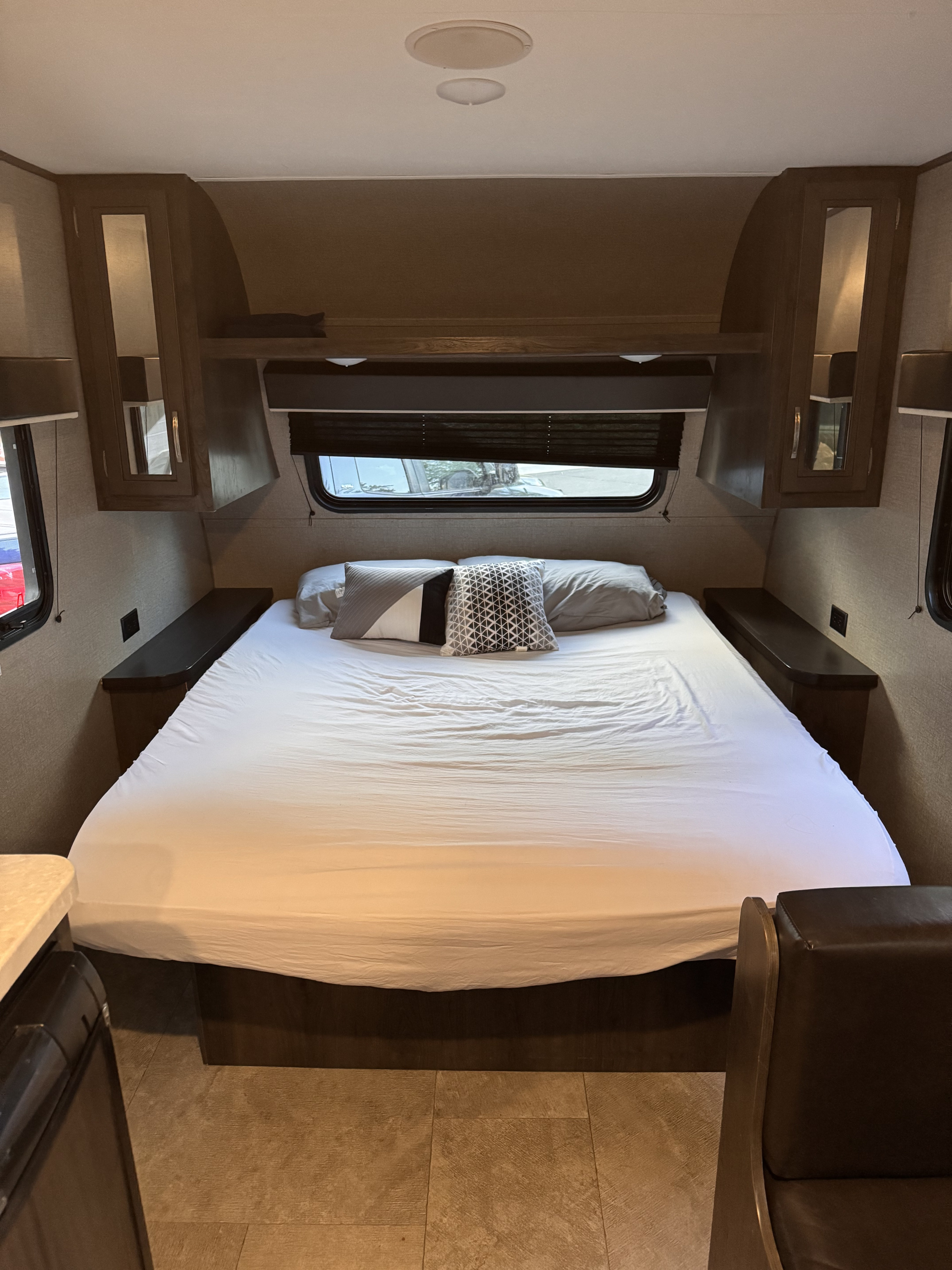 Comfortable RV rental bedroom with a queen bed, overhead storage, and side shelves. Perfect for road trips.. Jayco Jay Flight SLX Baja Edition 2020