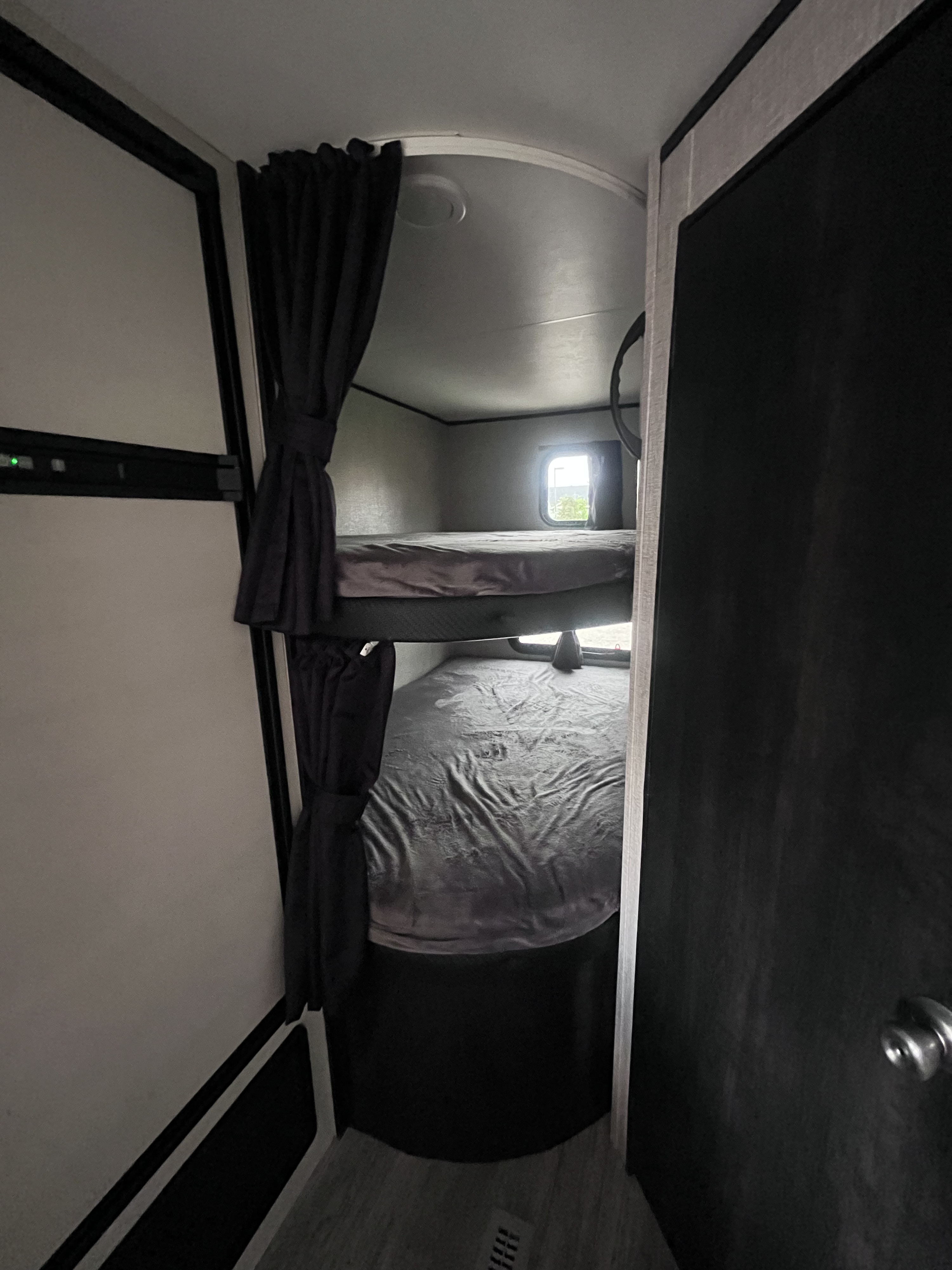 Inside this RV rental, dual bunk beds provide cozy sleeping quarters. Note the window and ceiling light for convenience.. Jayco Jay Flight SLX 2022