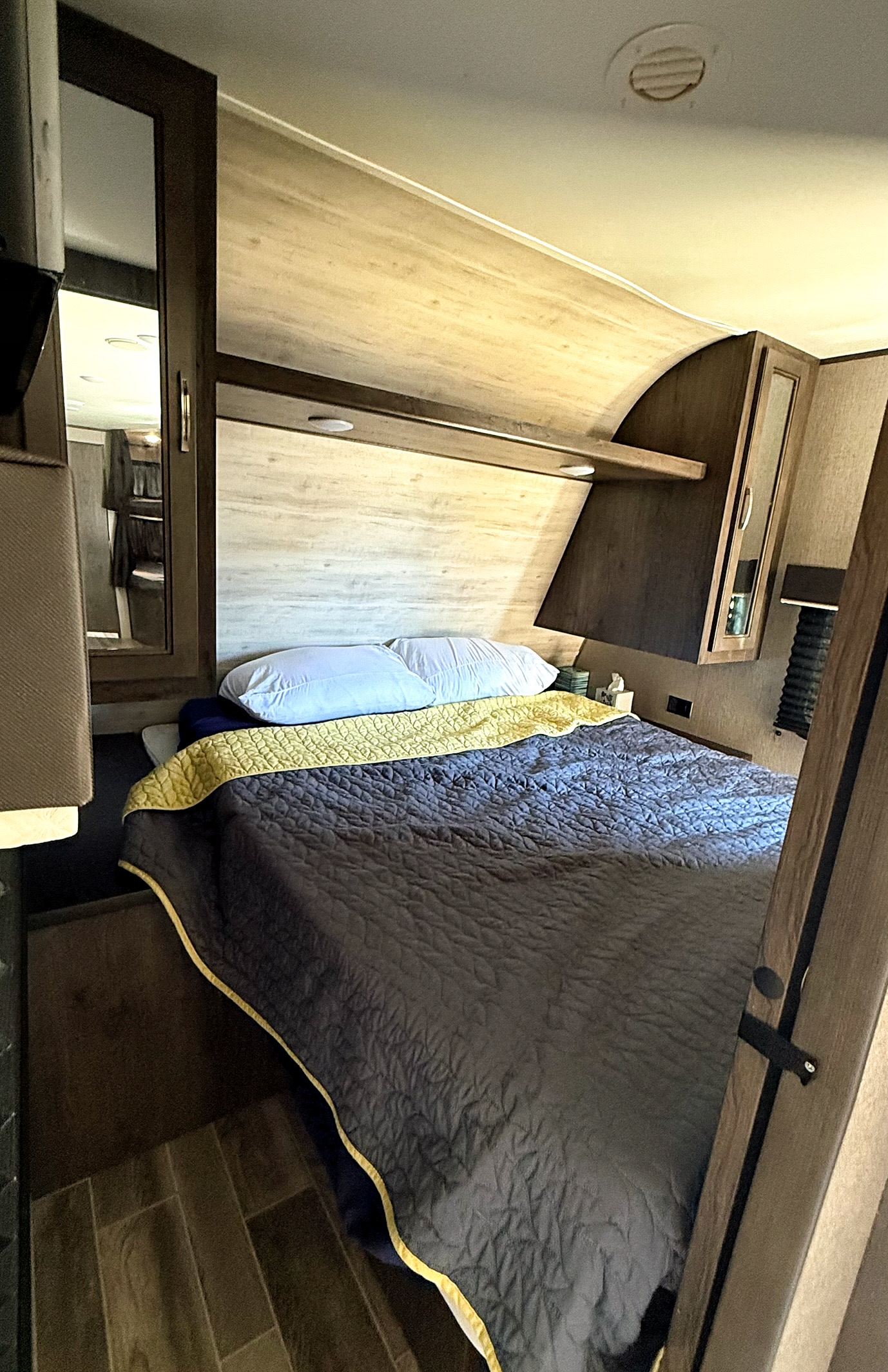 Relax in this cozy RV rental bedroom featuring a comfortable bed, overhead storage, and mirrored closet. Ideal for travel adventures.. Jayco Jay Flight SLX 2021