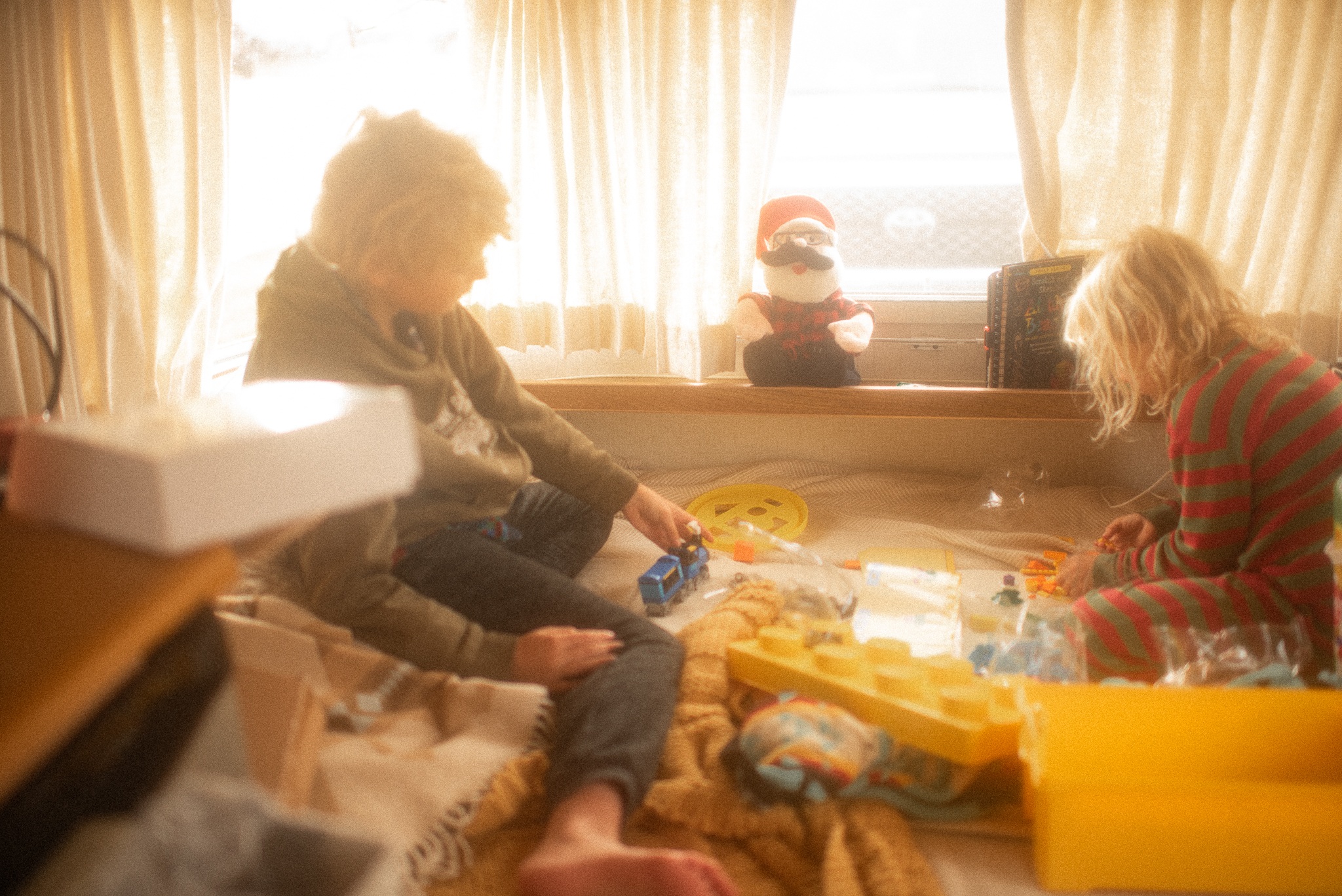 Two kids play with toys in a cozy RV rental, perfect for family camping and travel adventures.. Airstream Argosy 1977