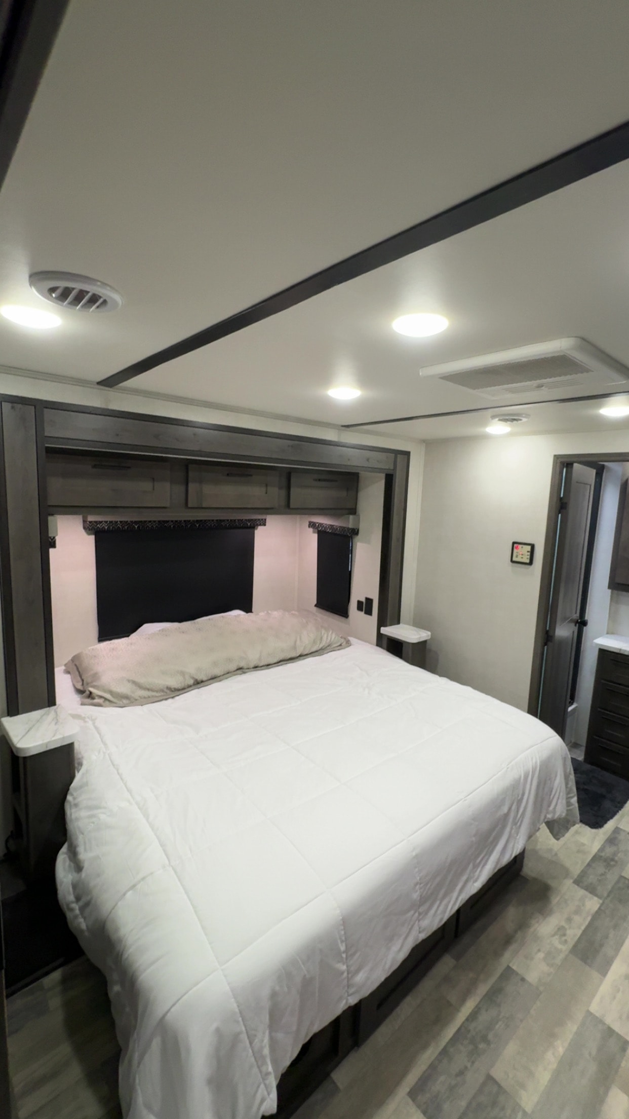 Comfortable RV rental bedroom with white bed, overhead storage, and modern lighting.. FR3 FR3 Motorhome 2022