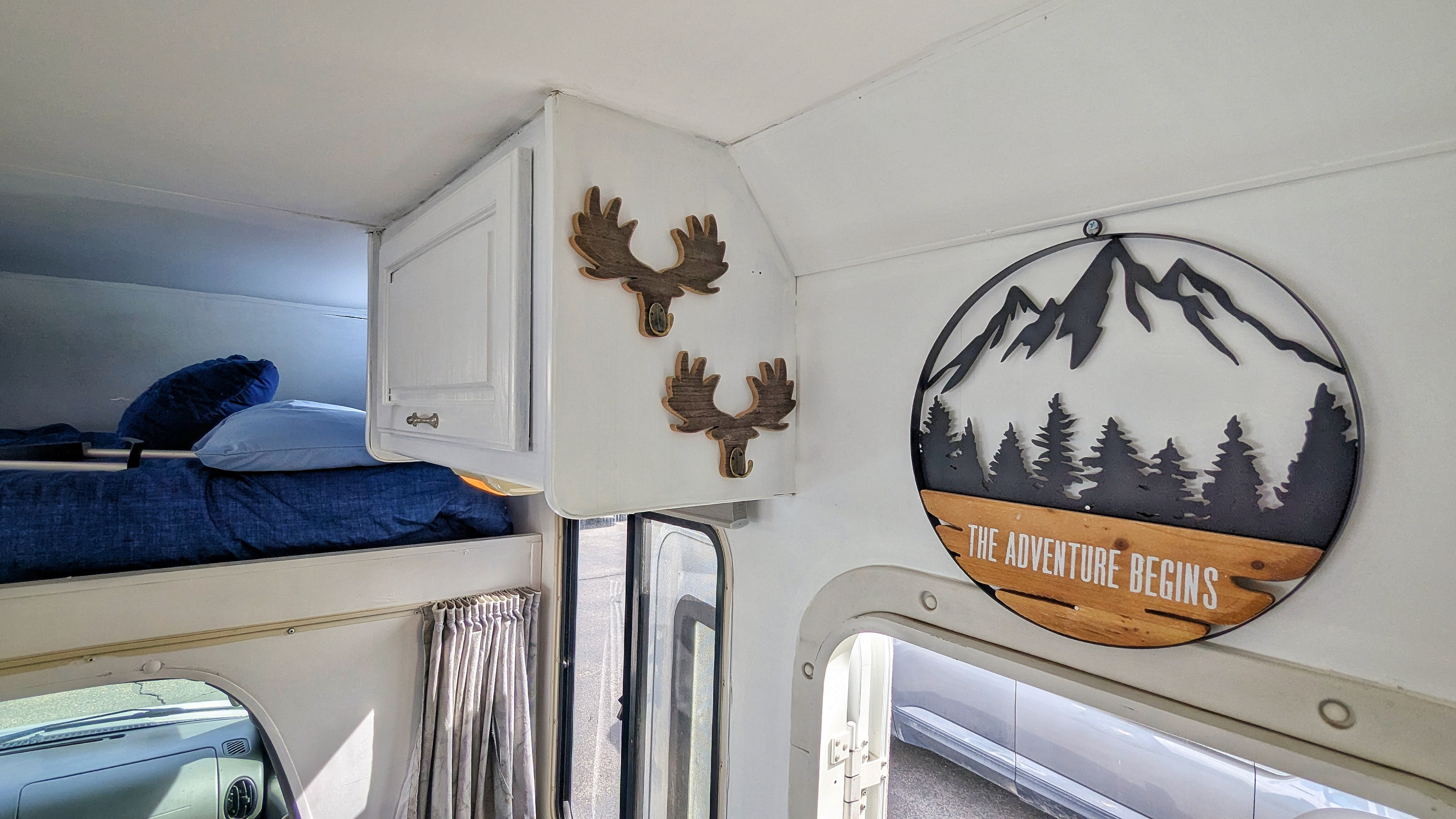Step into this RV rental! Features a cozy overhead bed, storage, and 'The Adventure Begins' decor.. Four Winds Majestic 2004