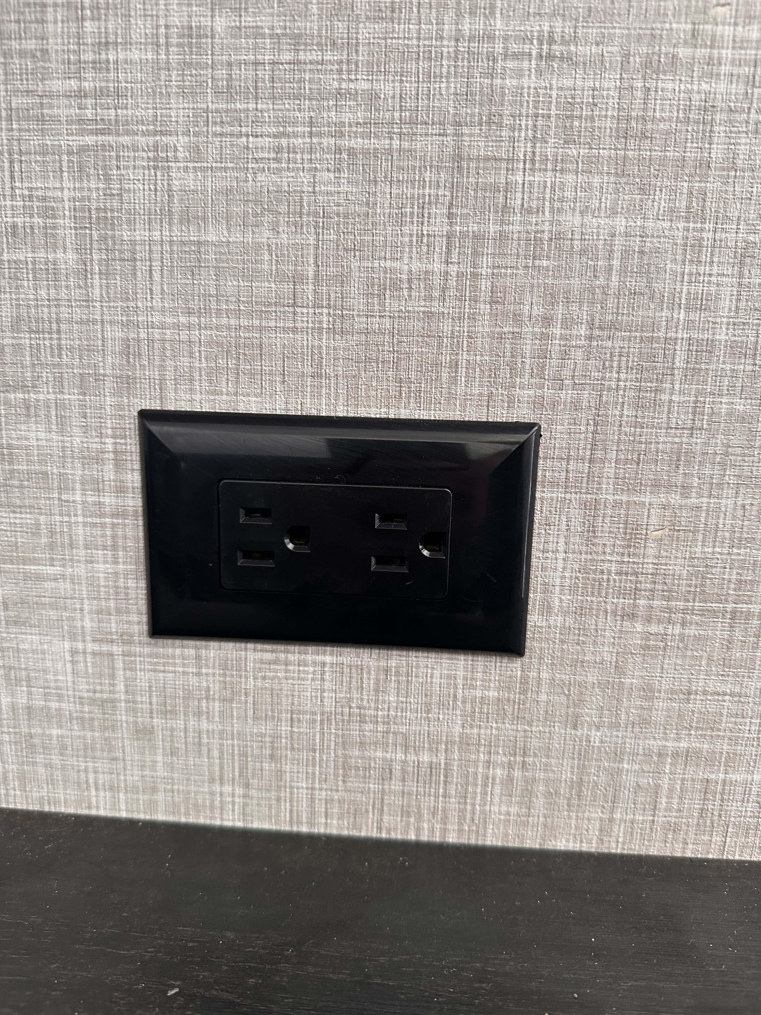 Black AC wall outlet with dual USB ports on a light gray textured wall, typical for an RV rental.. Jayco Jay Flight SLX 2024