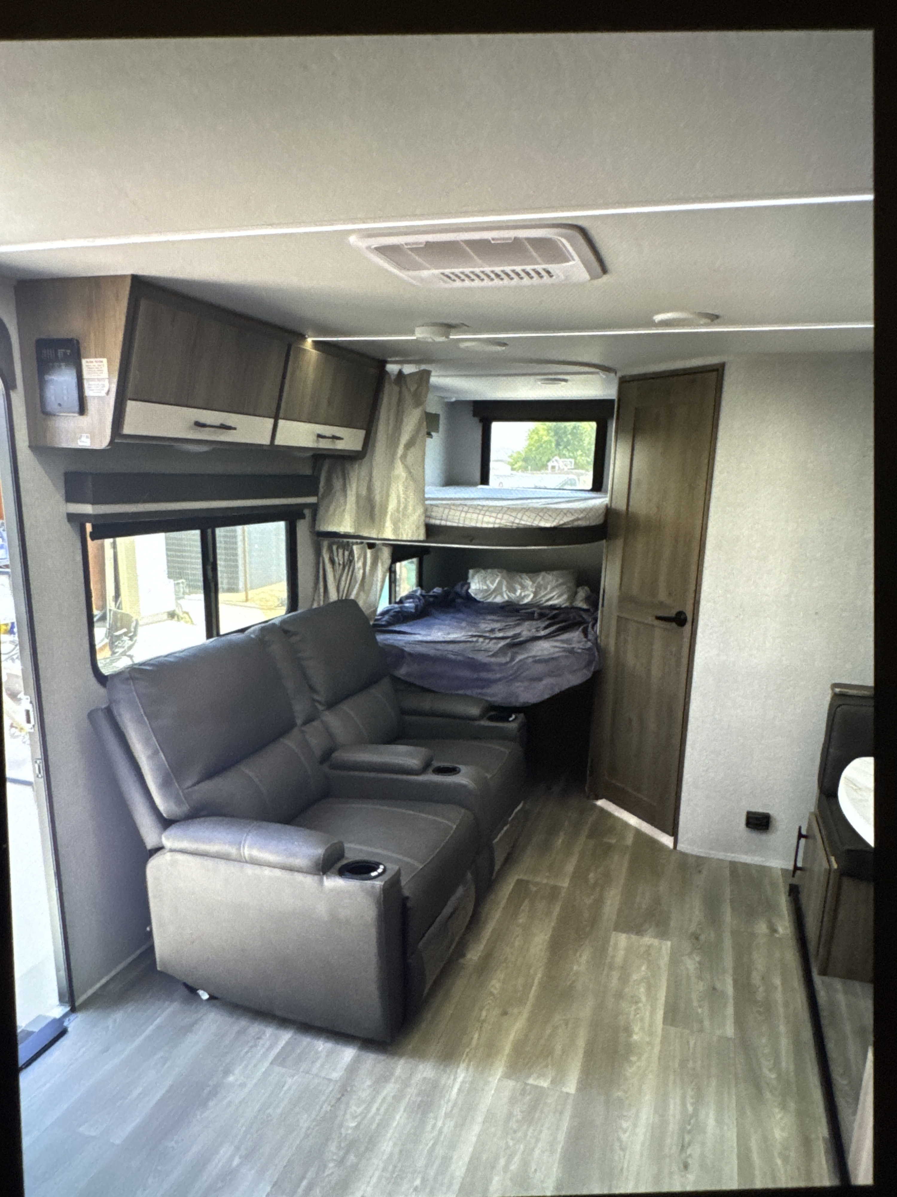RV rental interior: cozy recliners, bunk beds, overhead cabinets, and wood floors for a comfortable trip.. Grand Designs 25DBE 2025