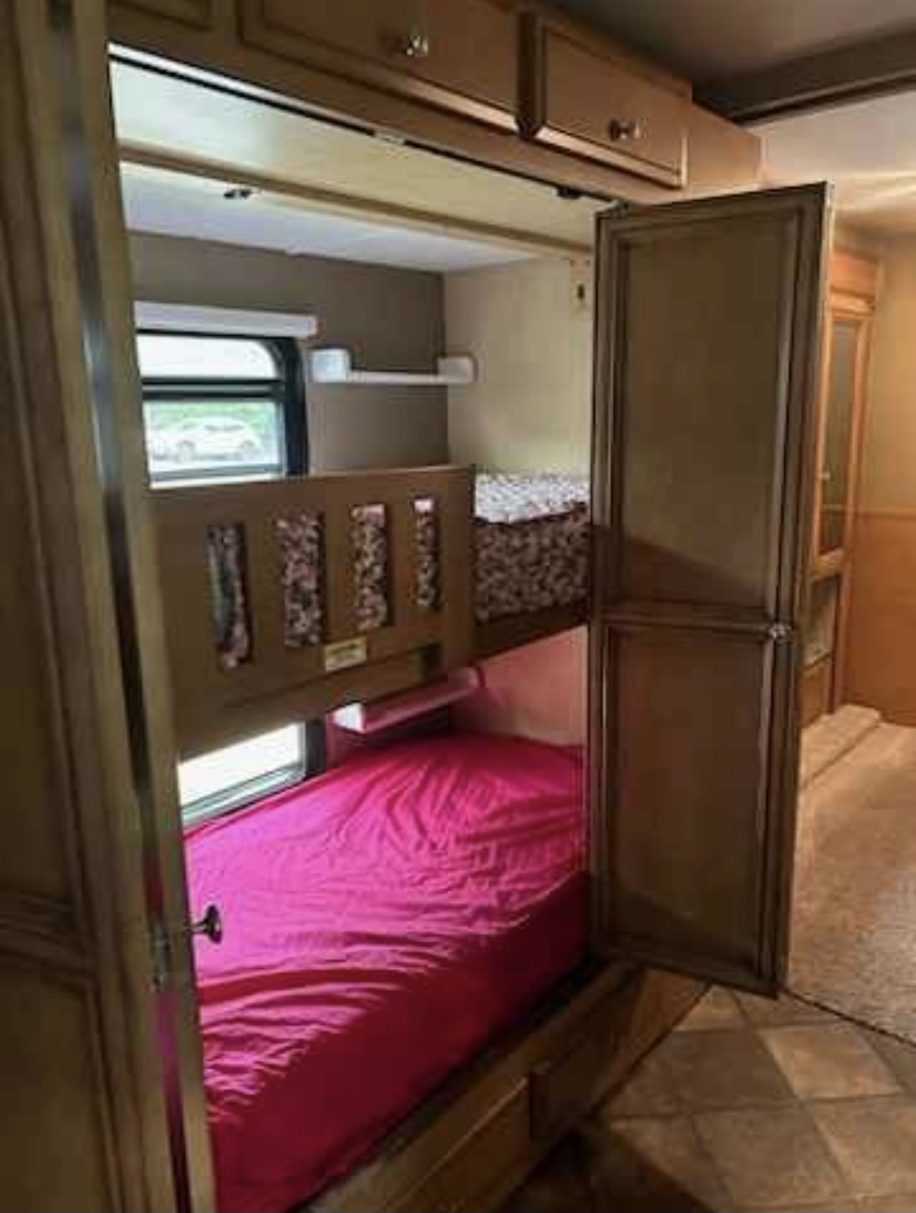 RV rental interior: cozy bunk beds with a bright pink lower bunk and window view. Perfect for family adventures.. Ford/Newmar Baystar Sport 2015