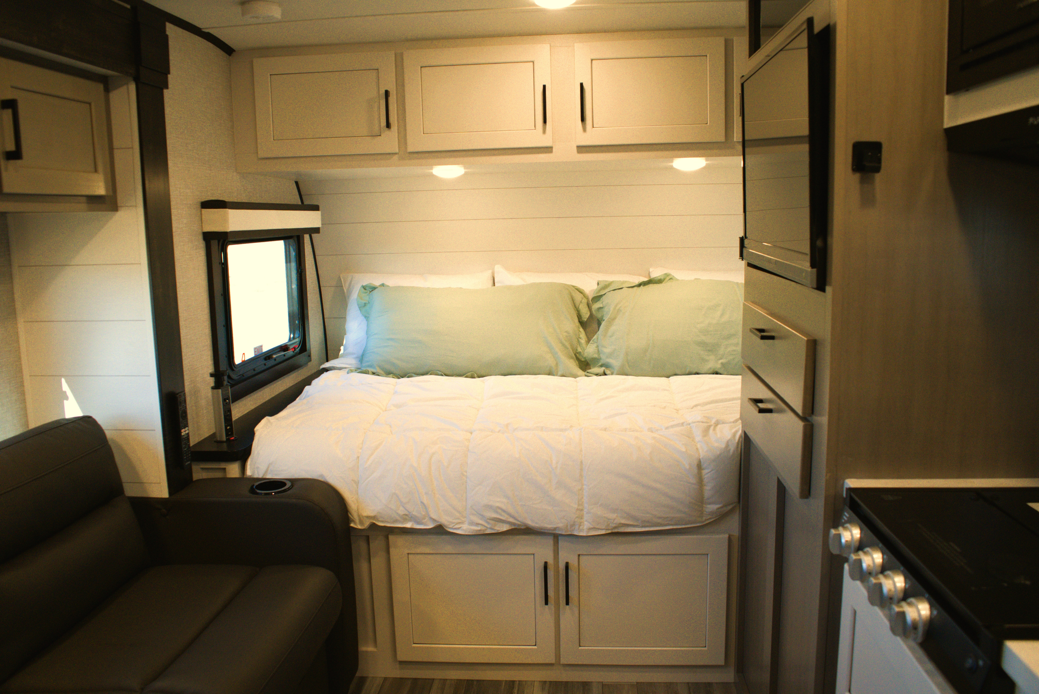 Comfortable RV rental interior showcasing a modern bedroom with storage, compact living space, and kitchen amenities.. Jayco Jay Feather Micro 2024