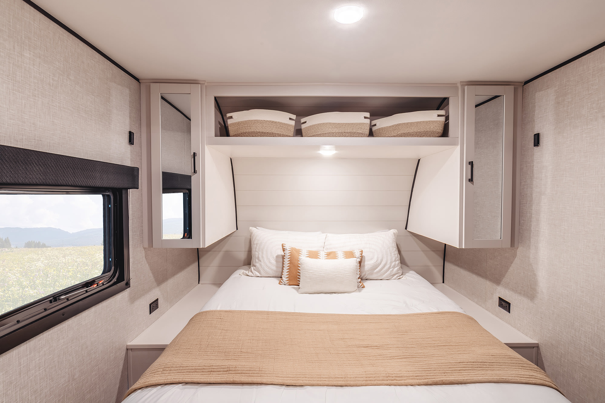 Modern RV rental bedroom offers a comfortable bed, smart storage, and scenic window view for your travels.. Go Play 26RLS 2025
