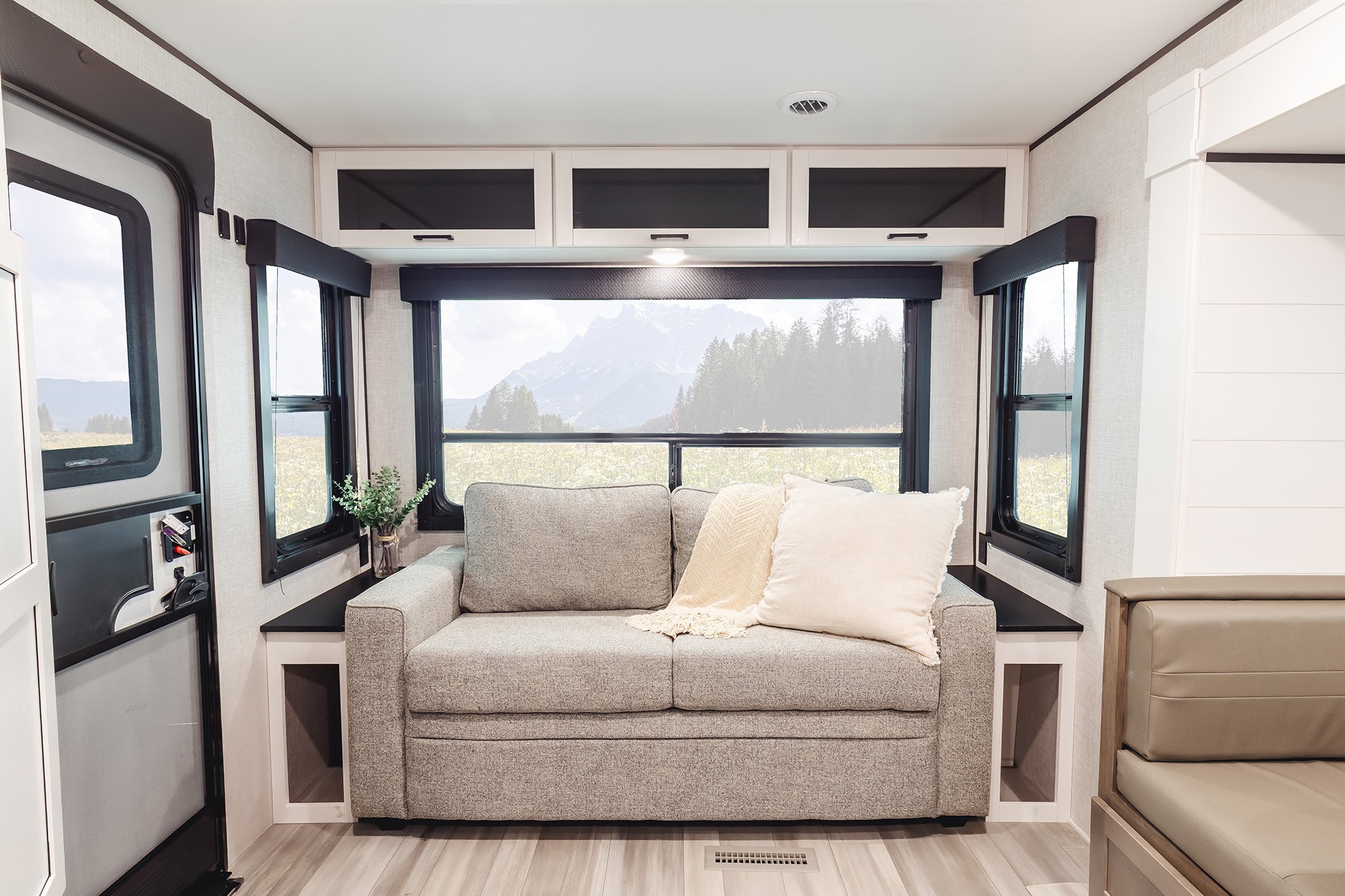 This RV rental offers a cozy living space with a comfy sofa and scenic mountain views from its large windows.. Go Play 26RLS 2025