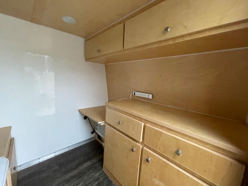 This RV rental interior features light wood cabinetry, a power strip, and functional storage, ideal for a comfortable camper setup.. RUSTIC TRAIL KODIAK STEALTH 2020