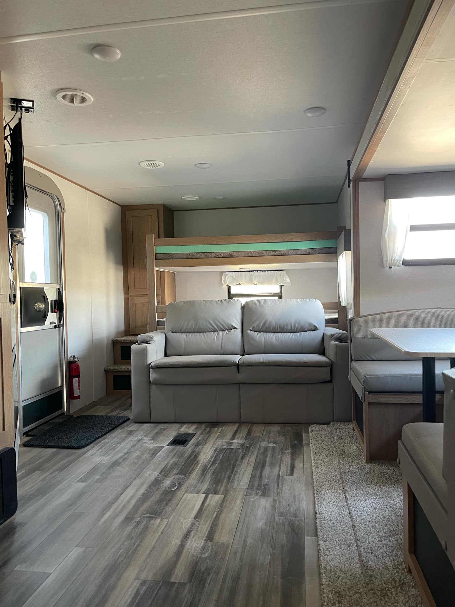 Spacious RV rental interior featuring a comfy sofa, dining area (dinette), and bunk beds. Ideal for travel and family fun.. Avenger Avenger Trailer 2022
