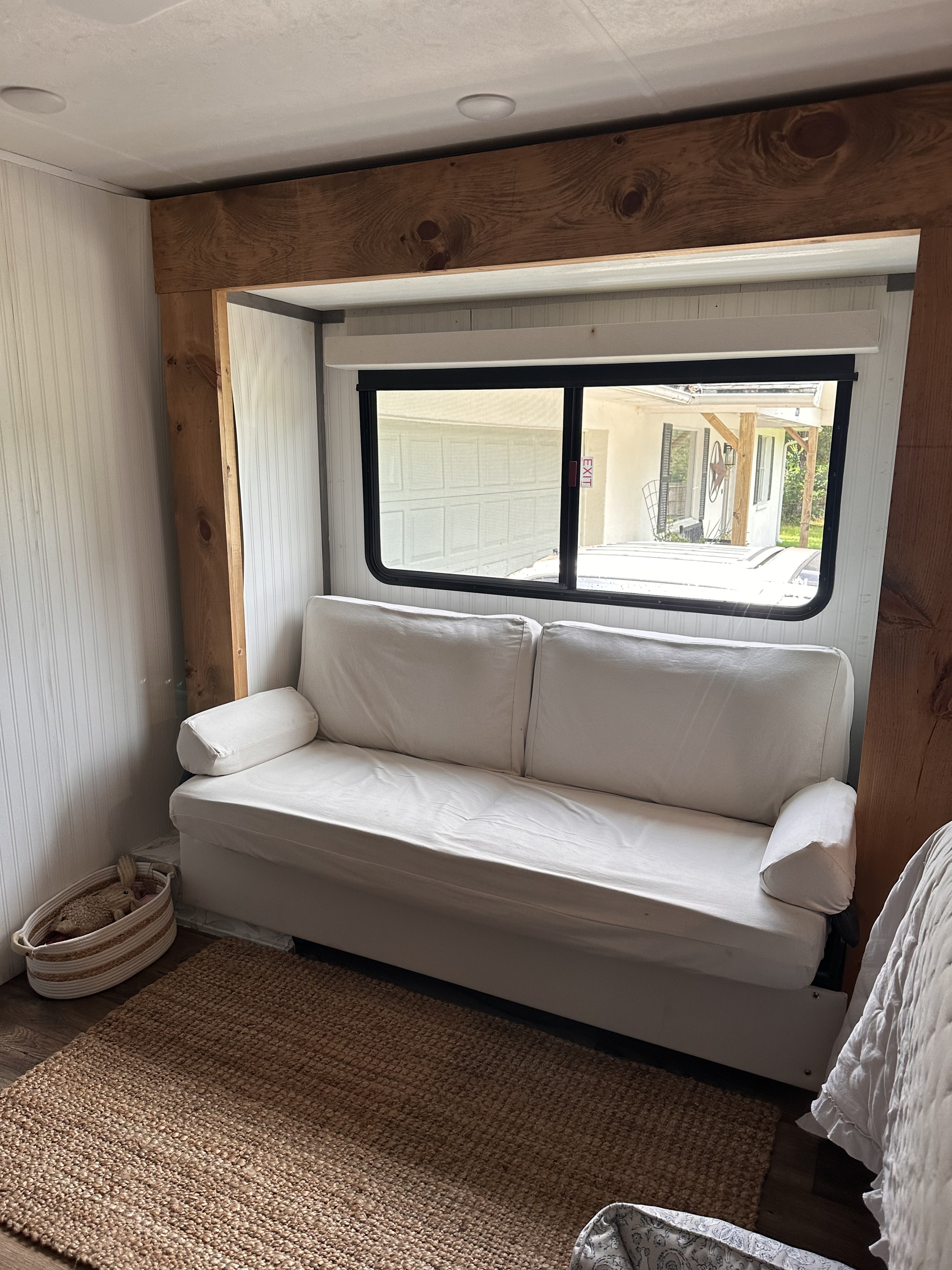 Modern RV rental kitchen featuring grey cabinets, butcher block counters, stone-look backsplash, TV, and appliances.. Dutchmen Kodiak Cub 2022