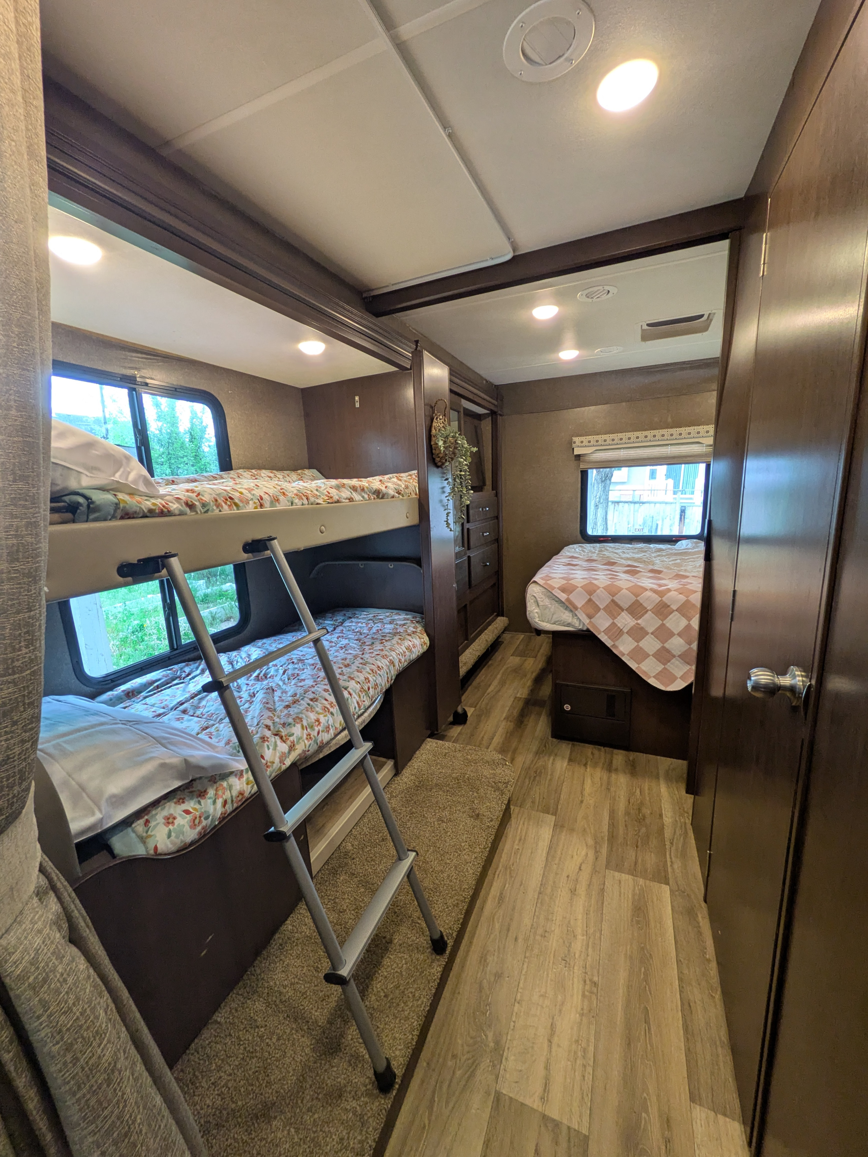 Cozy RV rental interior featuring bunk beds, a queen bed, and ample storage, perfect for family travel adventures.. Thor Four Winds 2020
