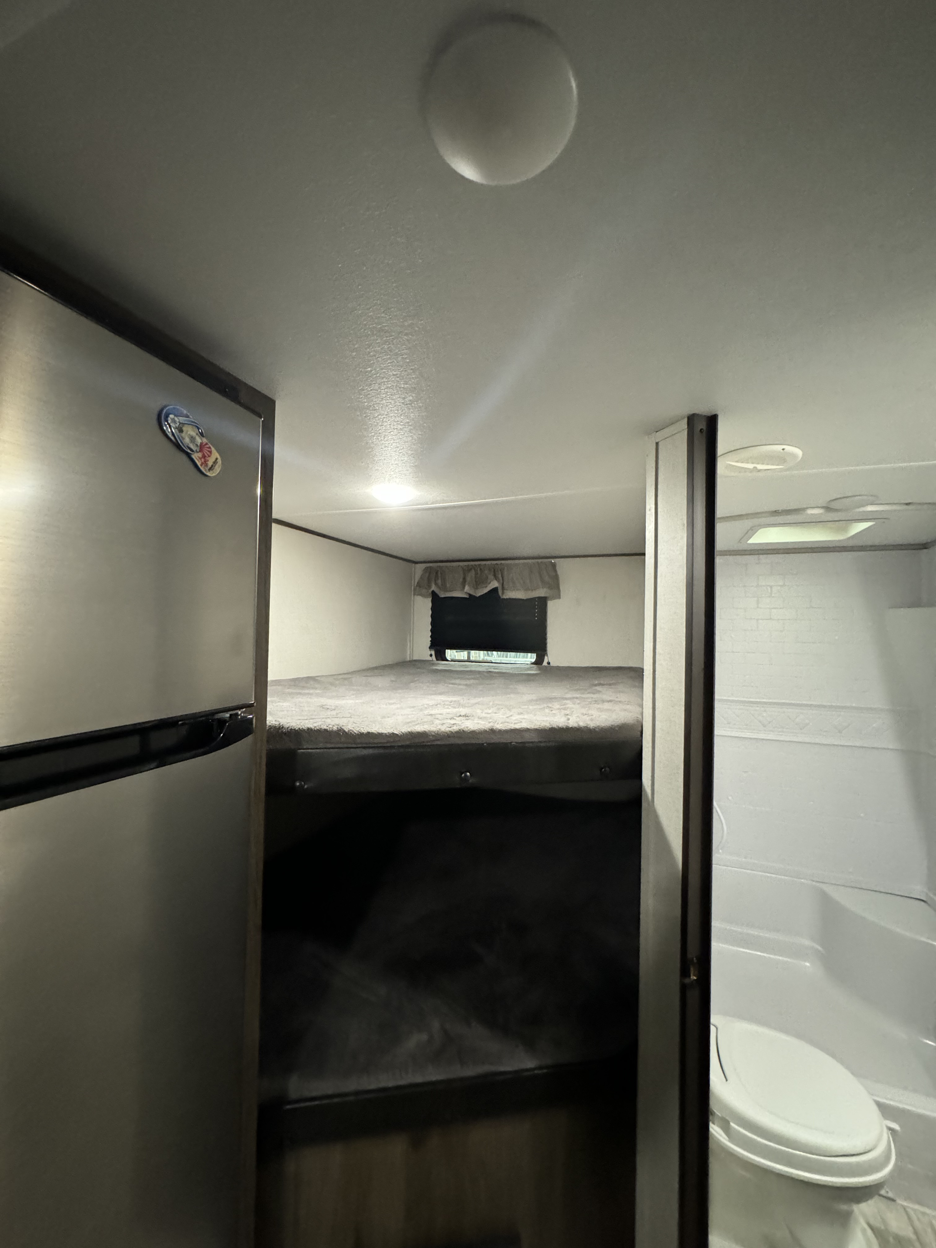 RV rental interior featuring bunk beds, a stainless steel refrigerator, and a compact bathroom with a toilet and shower.. Avenger Avenger Trailer 2021