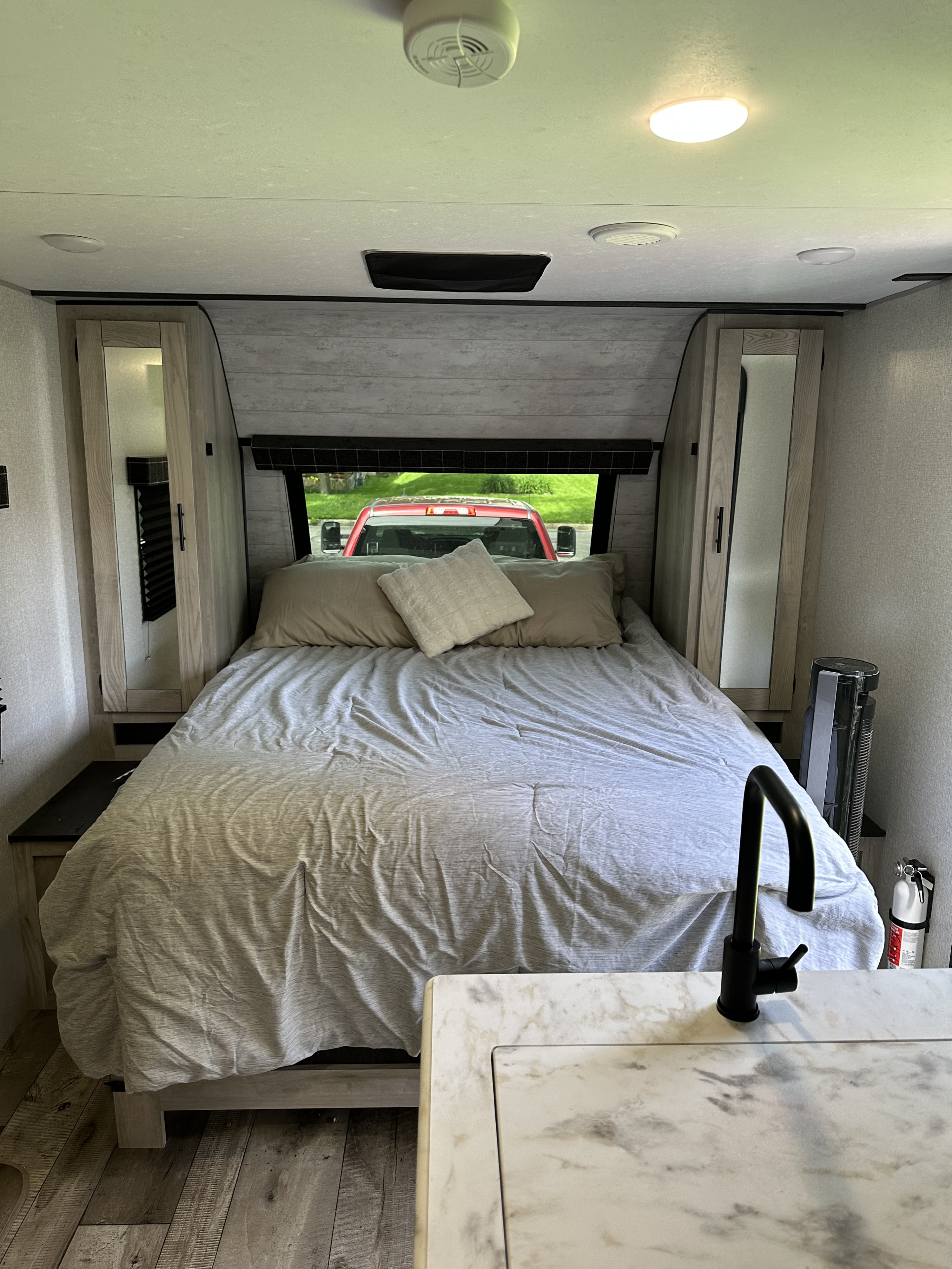 Inside an RV rental: a compact bedroom with a cozy bed and storage, blending into a functional kitchen space.. KZ Connect C231BHKSE 2023