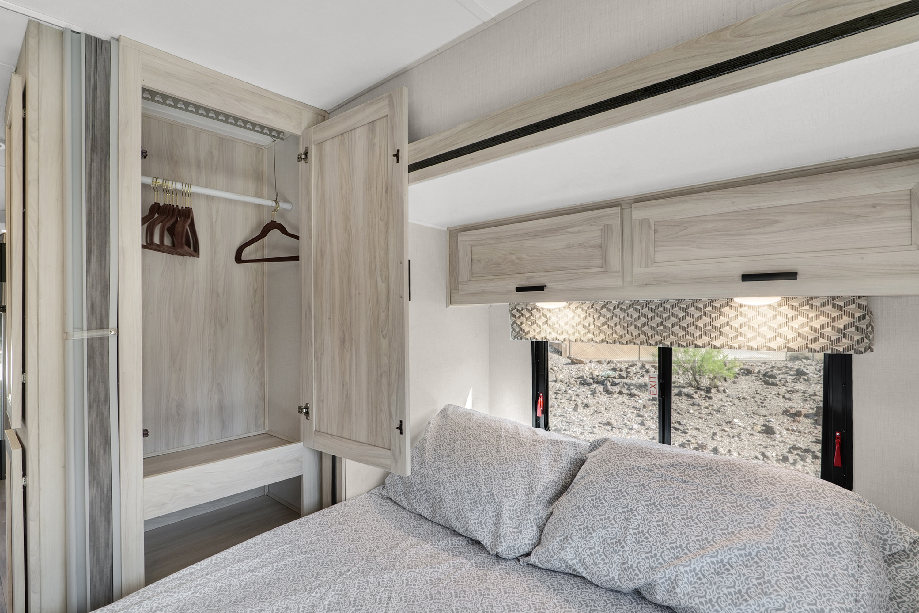 Cozy RV rental bedroom with an open closet, overhead storage, and a scenic window view.. Forester LE 2023