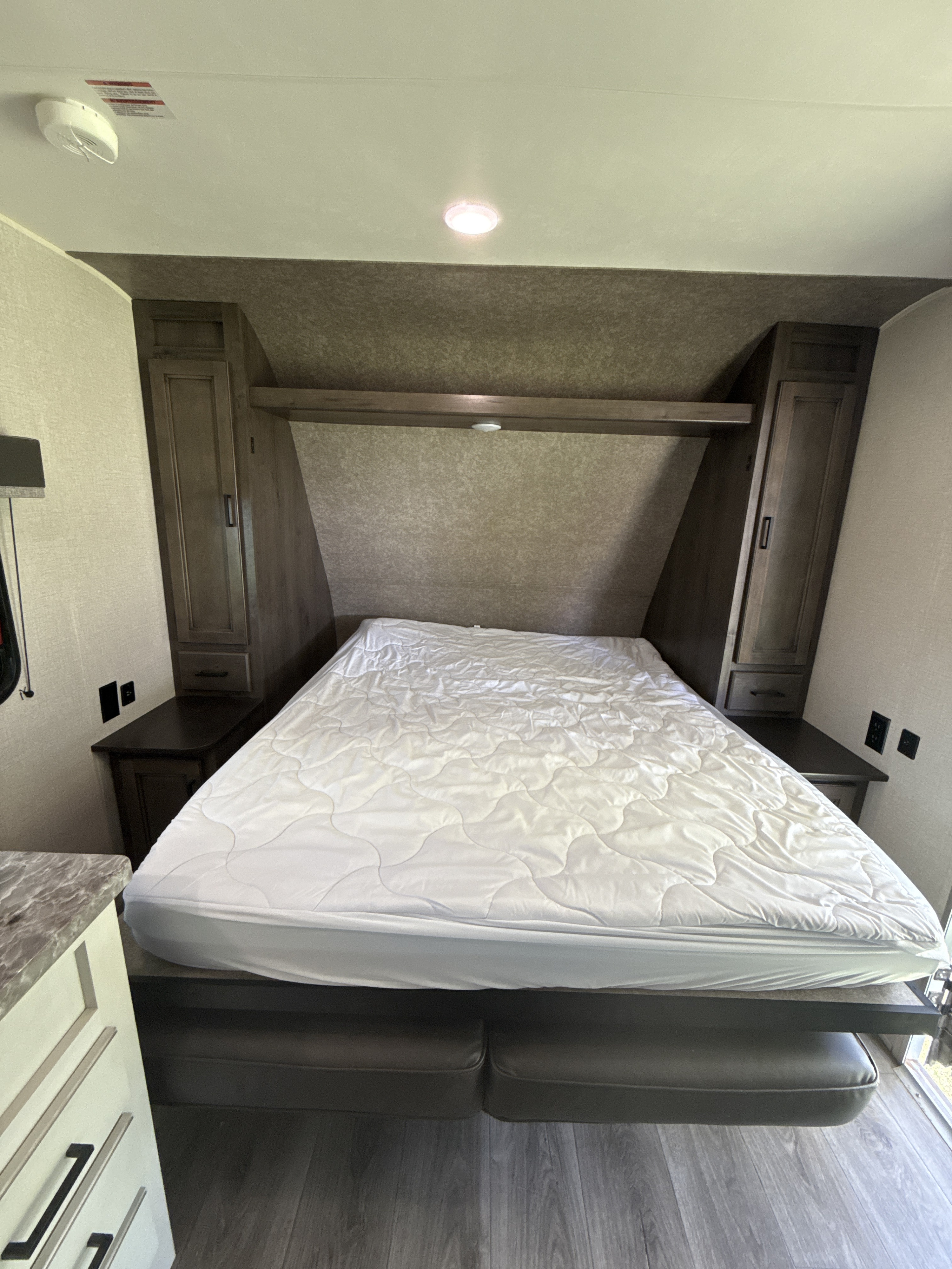 Experience comfort in this RV rental bedroom with a convertible bed, built-in storage, and modern interior.. Highland Ridge RV Open Range 2021