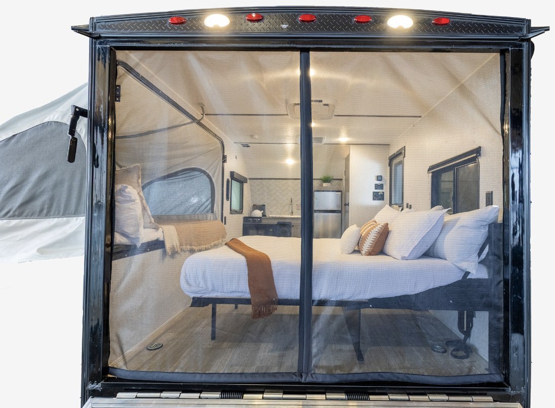Step inside this RV rental! A well-lit interior features a main bed, pop-out tent bed, & kitchen, all behind a mesh screen.. Go Lite Boulderback 2025