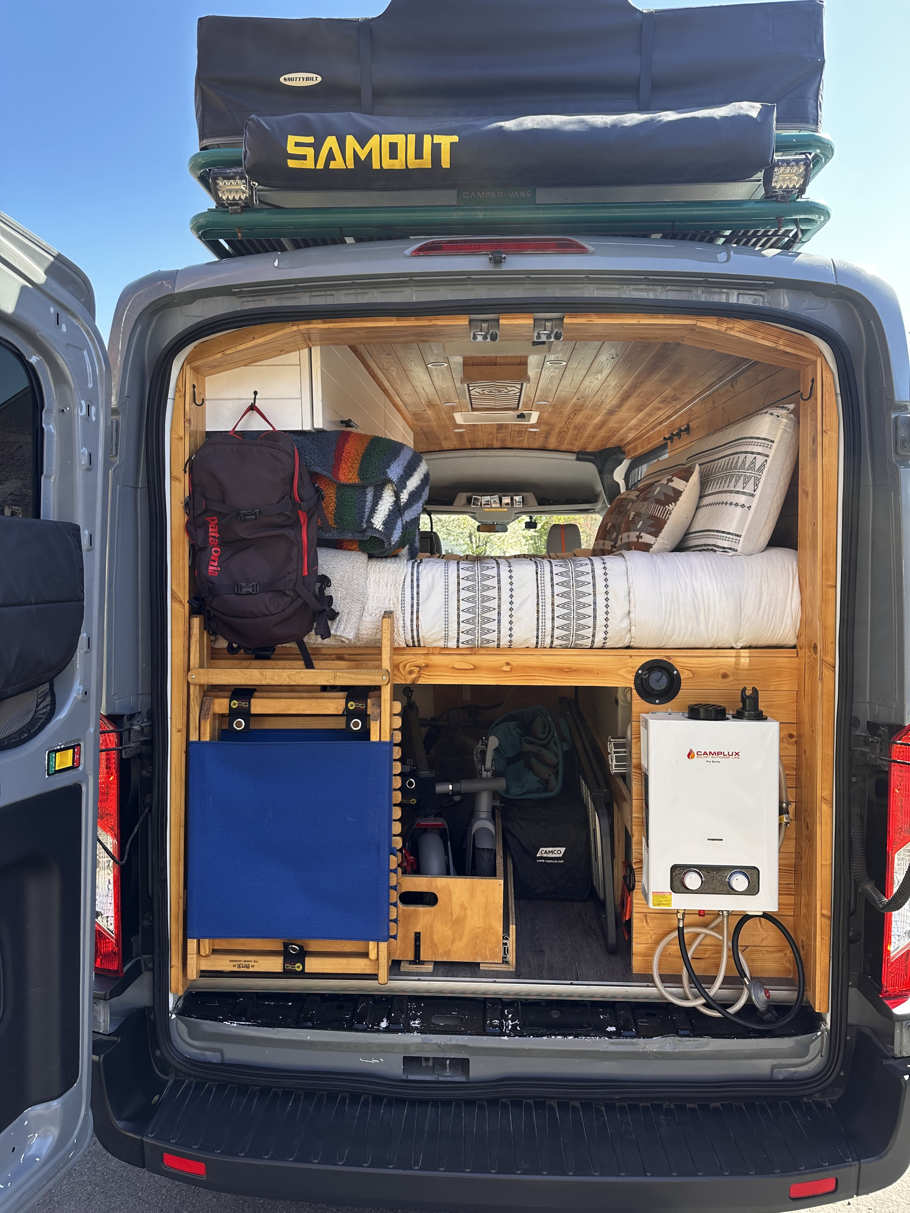 Custom RV rental interior: cozy bed, smart storage, and a portable water heater, perfect for adventure.. Ford Transit 250 2015