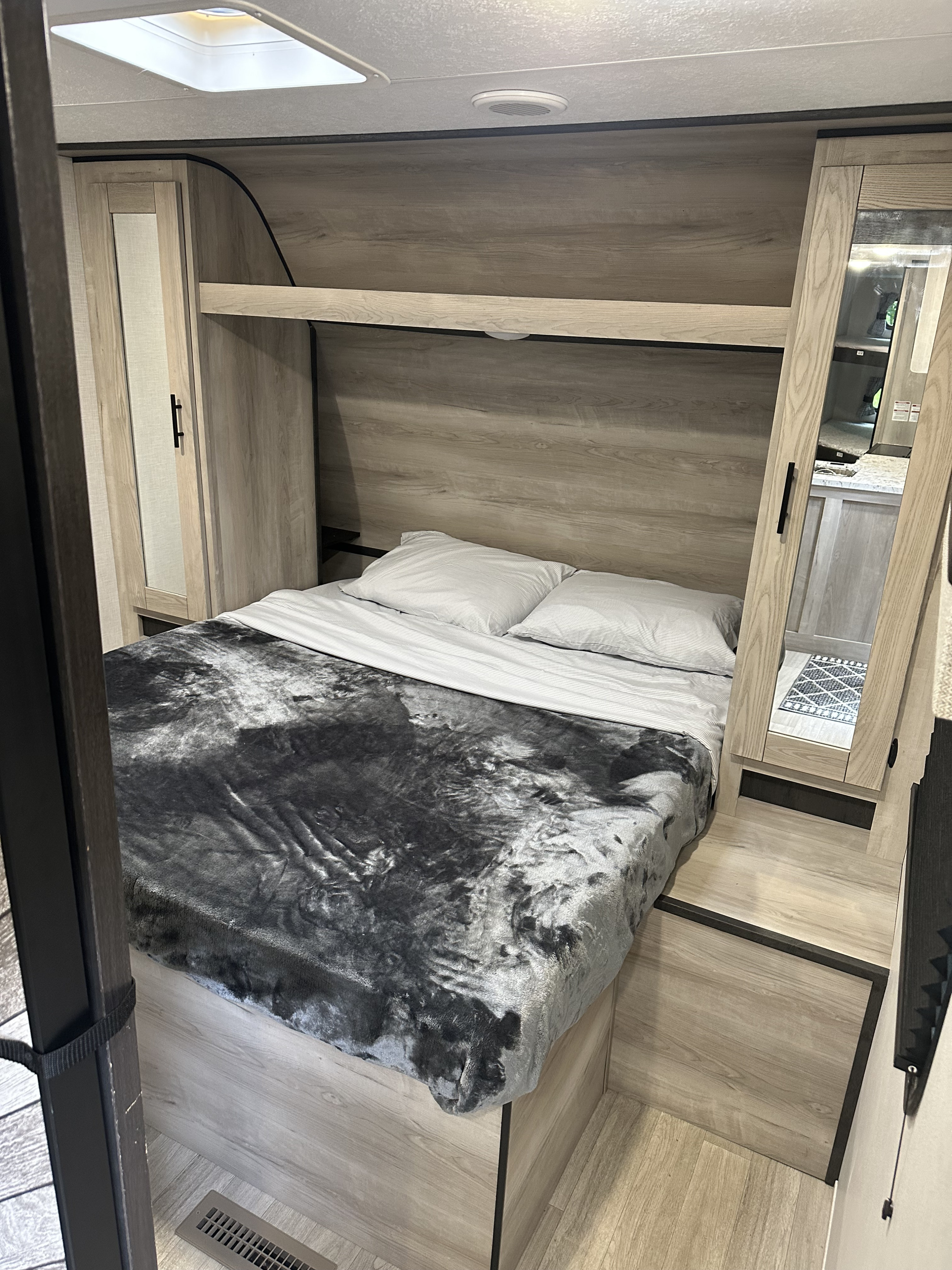 Cozy RV rental bedroom with light wood accents, built-in storage, and a comfy bed. Ideal for travel accommodation.. KZ Connect C241BHKSE 2024