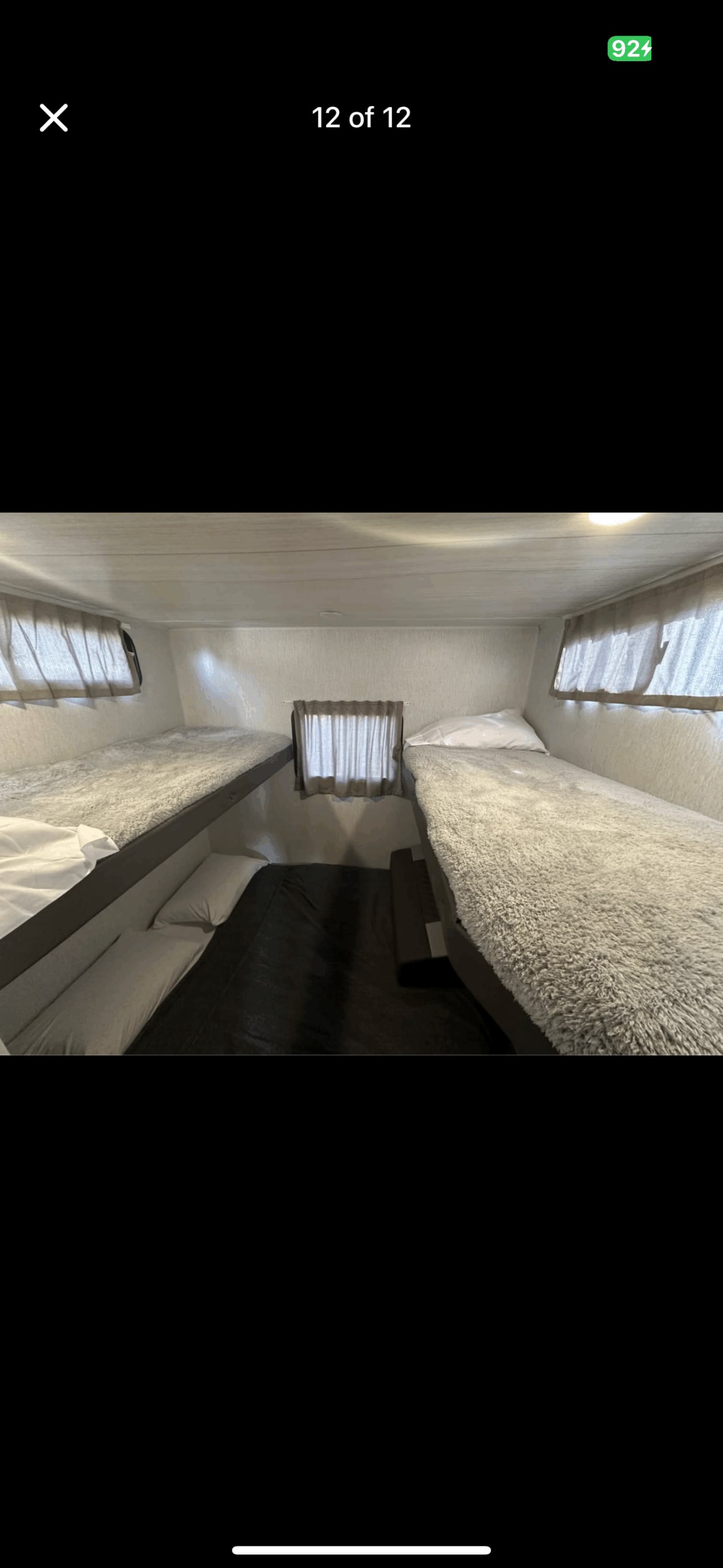 Inside an RV rental: a cozy bunk room featuring two bunk beds with soft blankets and additional floor sleeping space.. Forest River Wildwood 2024