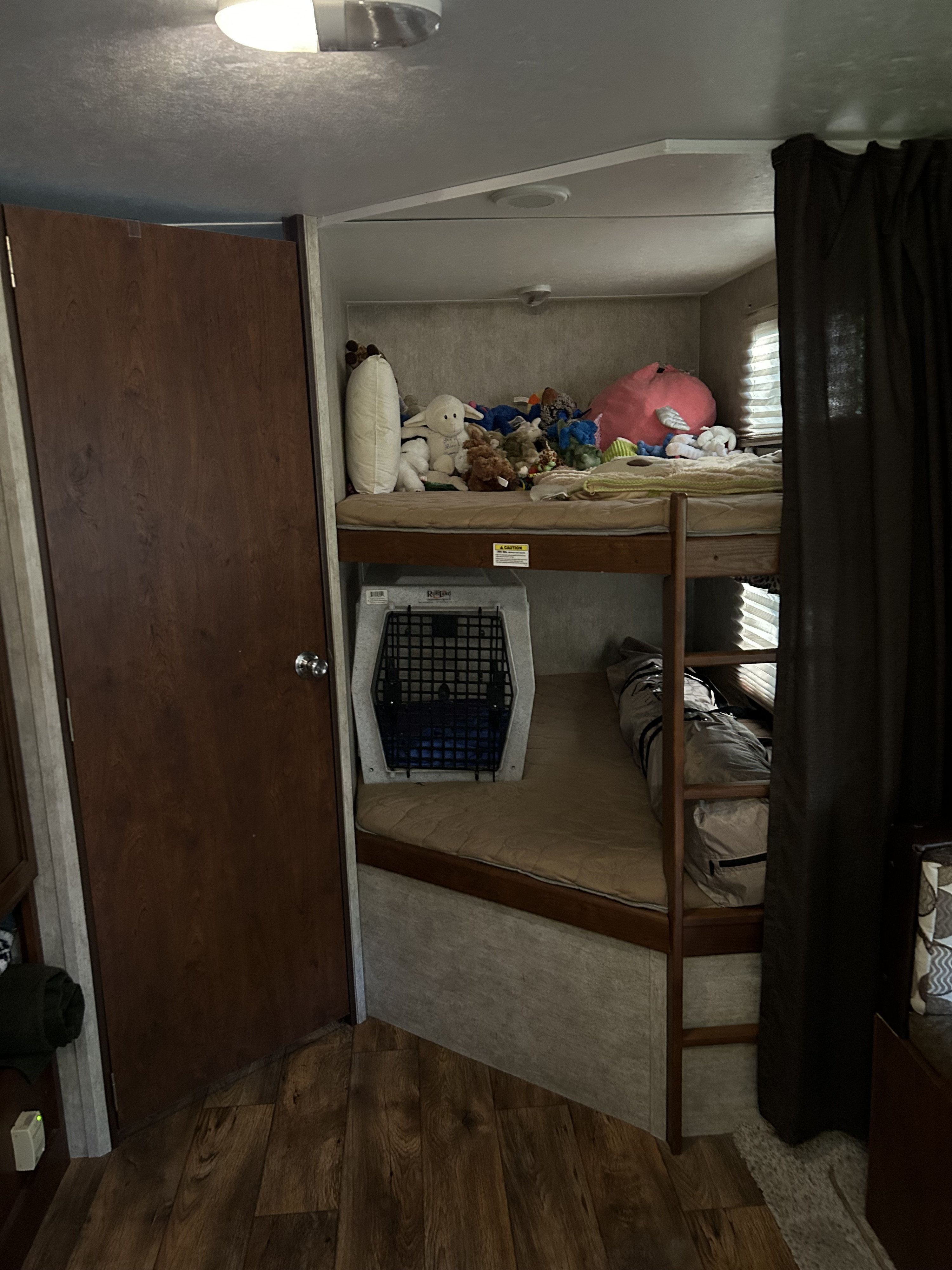 RV rental: Bunk beds filled with stuffed animals, a dog crate, and ladder in a compact interior for family travel.. Keystone RV Passport Grand Touring 2015