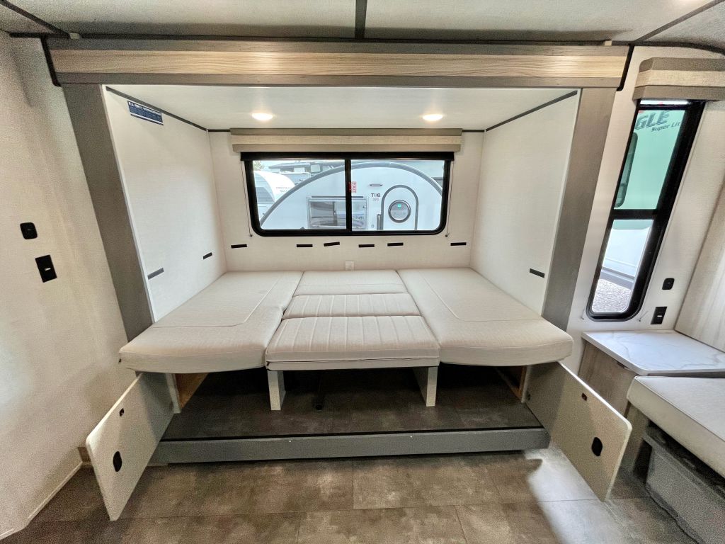 RV rental's adaptable interior: modular benches convert to a comfortable full bed, perfect for compact living.. Forest River Salem FSX 2025
