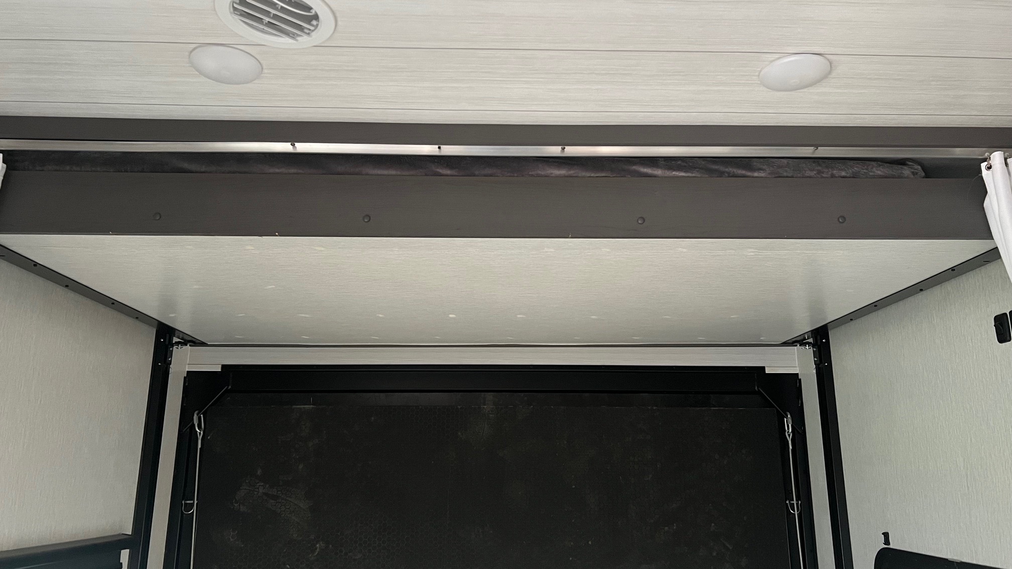 RV rental: Interior view of an RV's ceiling and a raised bunk bed, optimizing space in a toy hauler.. Forest River Stealth 2023