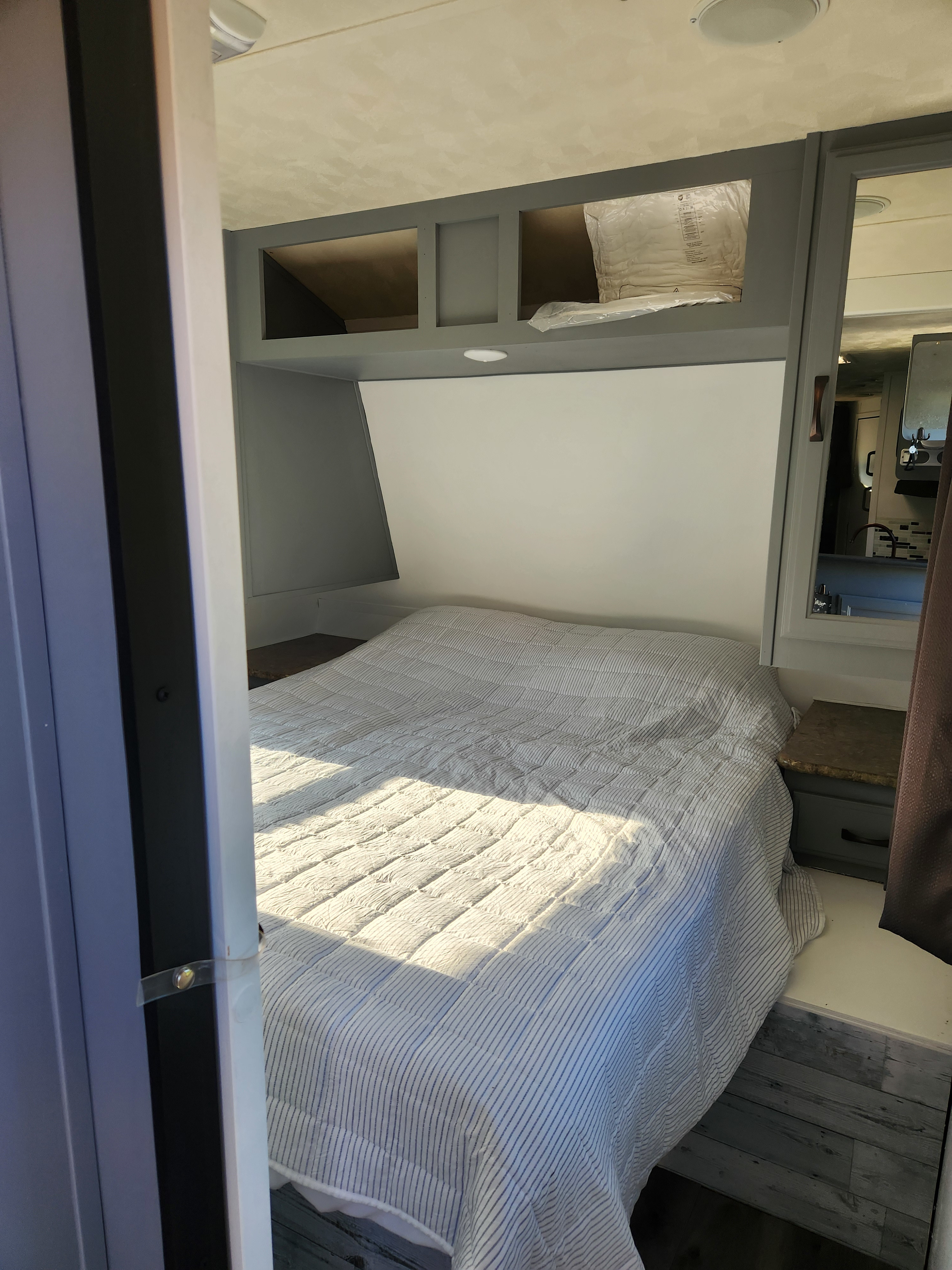 Step inside this cozy RV rental bedroom, featuring a comfortable bed, overhead storage, and bright, modern interior design.. Forest River Palomino Puma 2013
