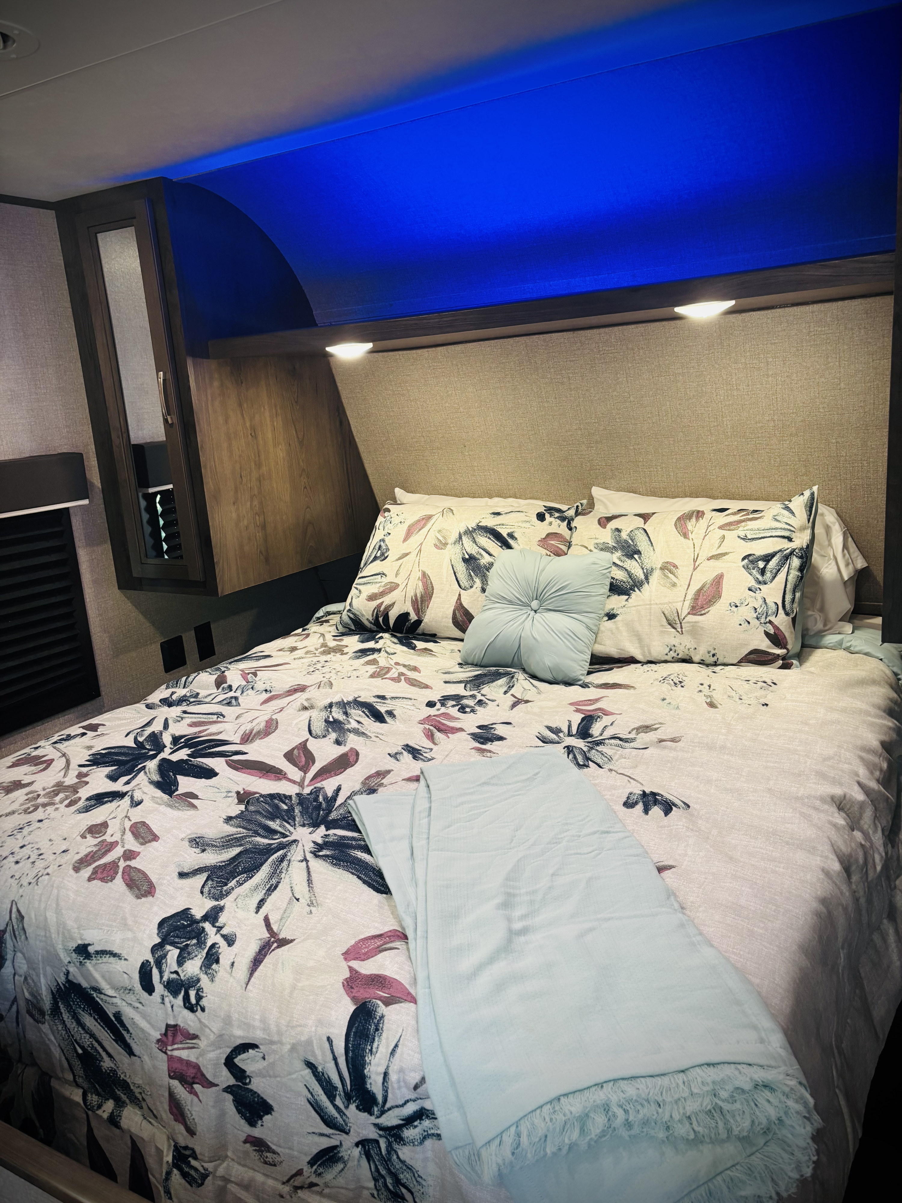 Comfortable RV rental bedroom featuring a floral bed, accent lighting, and convenient reading lights.. Jayco Jay Flight SLX 2020