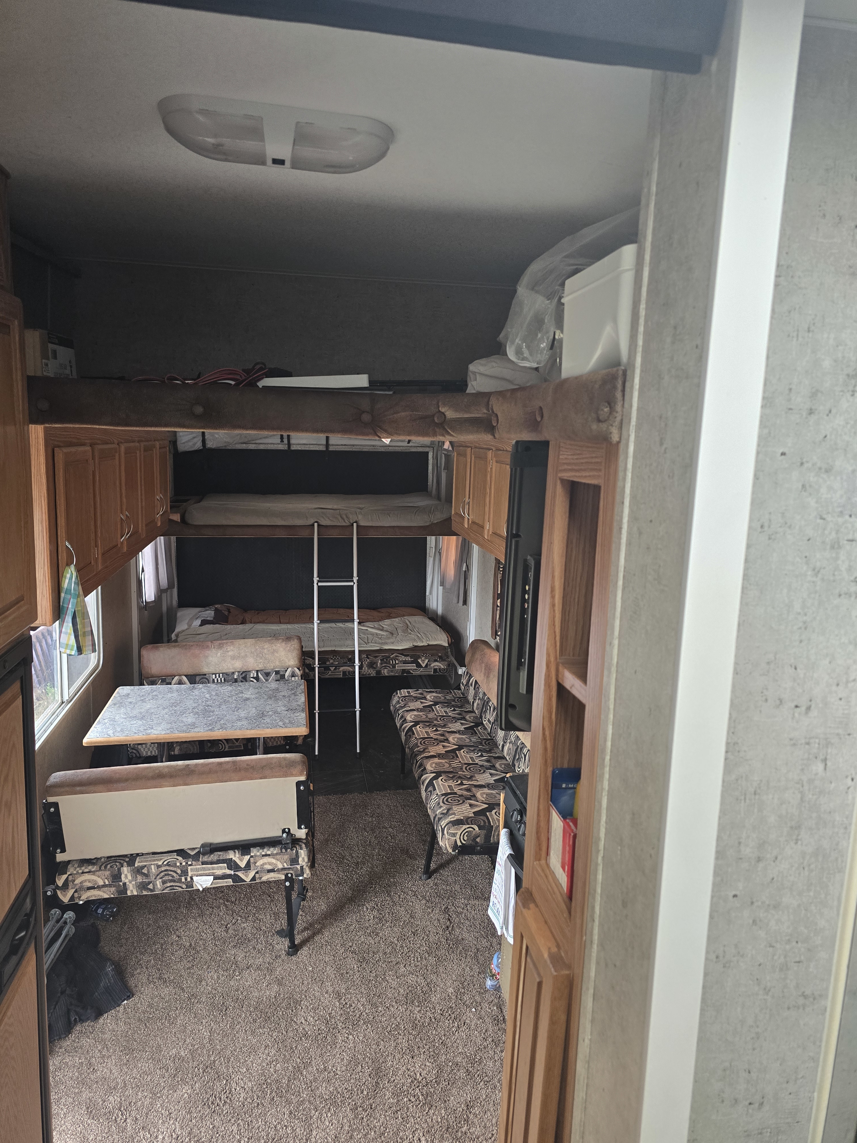 RV rental interior features comfortable bunk beds with a ladder, a dinette table, and lounge seating on carpeted floors.. Eclipse Recreational Vehicles Attitude 2008