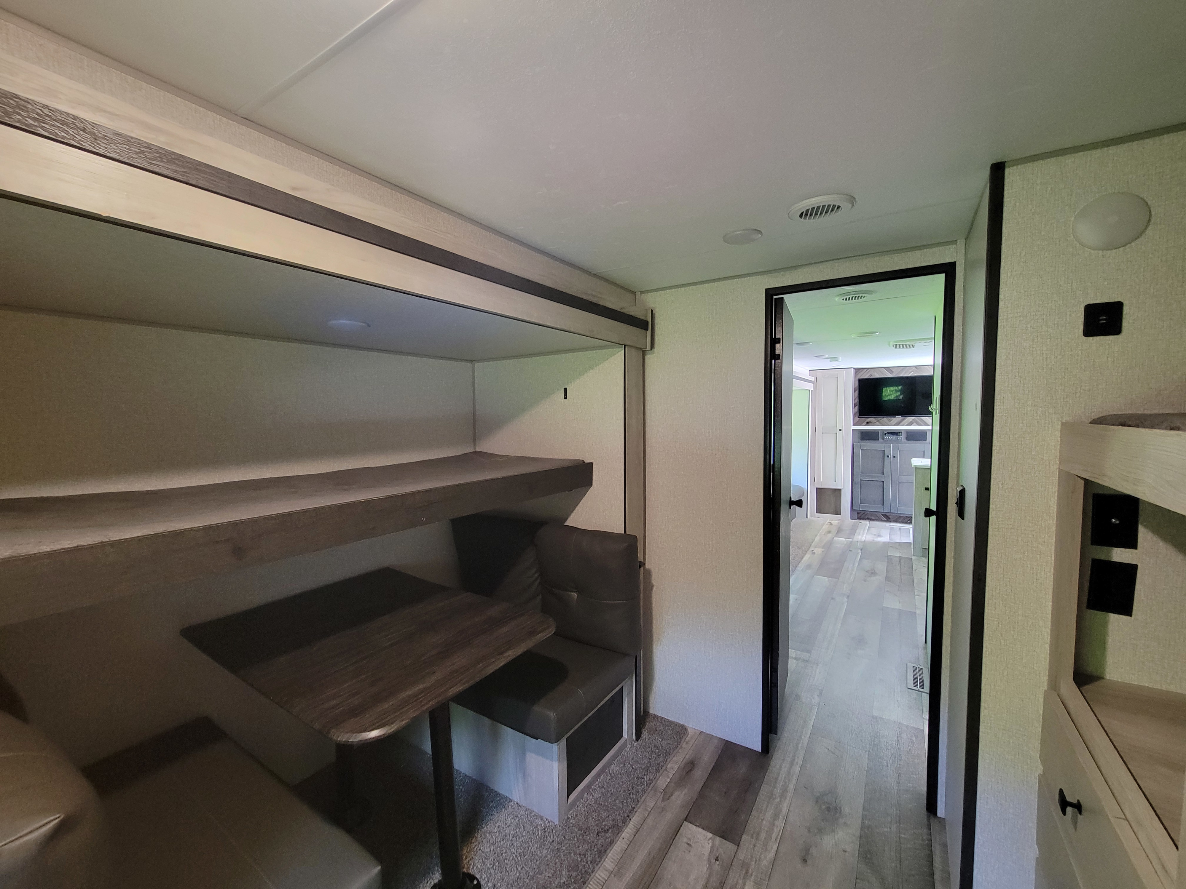 RV rental bunkhouse interior: features comfy bunk beds, a dinette, and view to the main living area.. Connect SE 2021