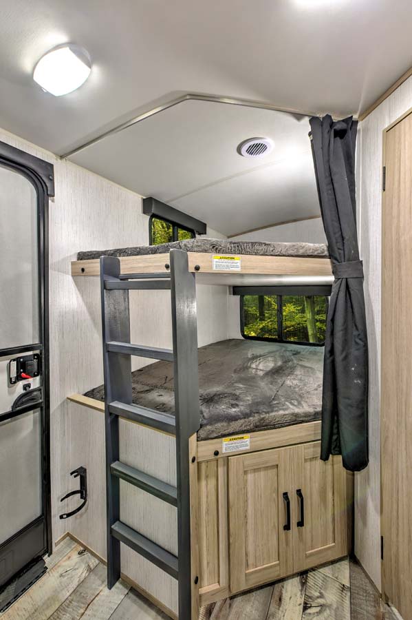 RV rental interior: cozy bunk beds with ladder & storage, perfect for family camping or travel.. Heartland RVs Sundance Ultra Lite 2022
