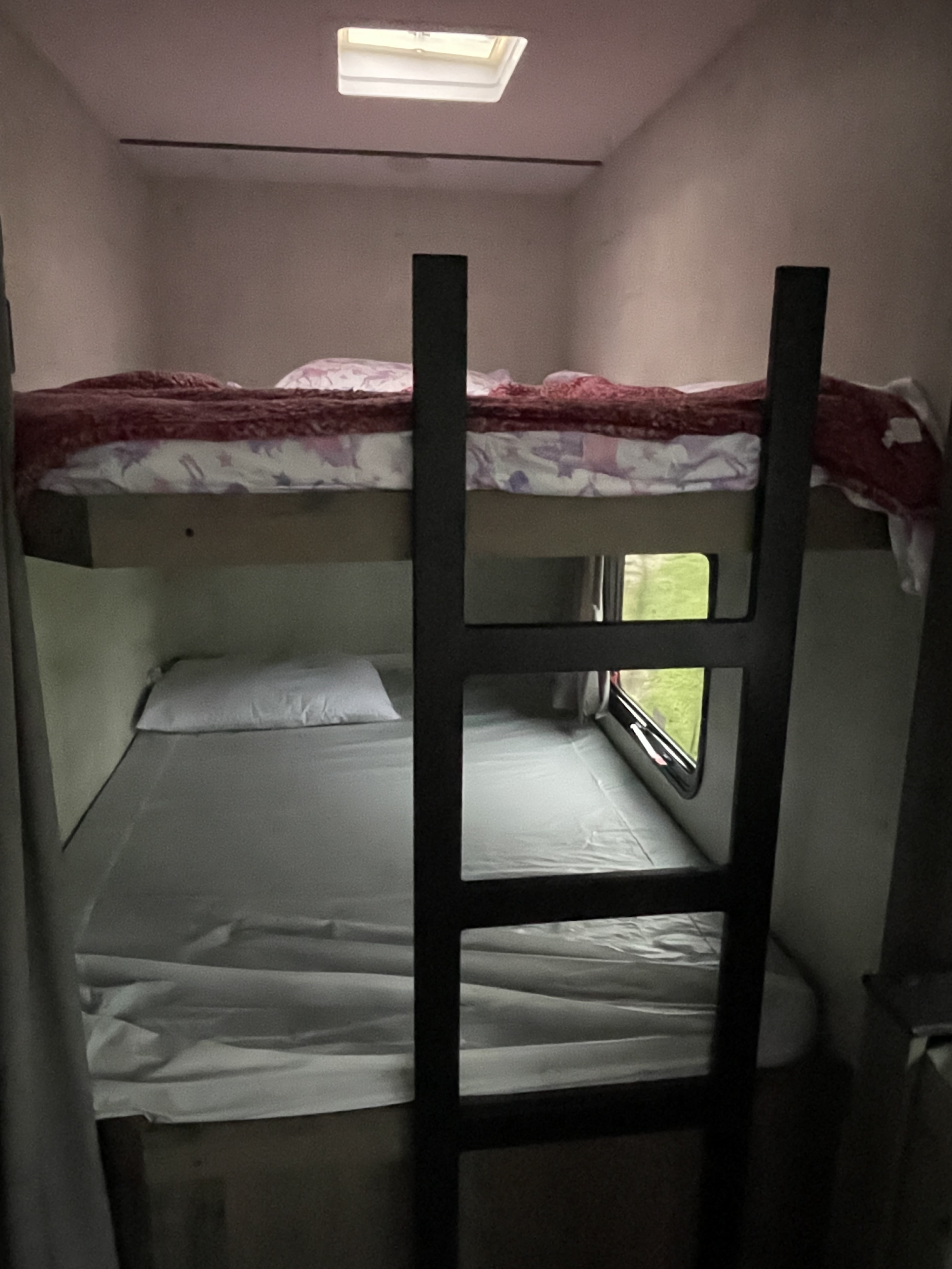 RV rental bunk beds: cozy sleeping setup with a skylight & window.. Gulf Stream Ameri-Lite 2022