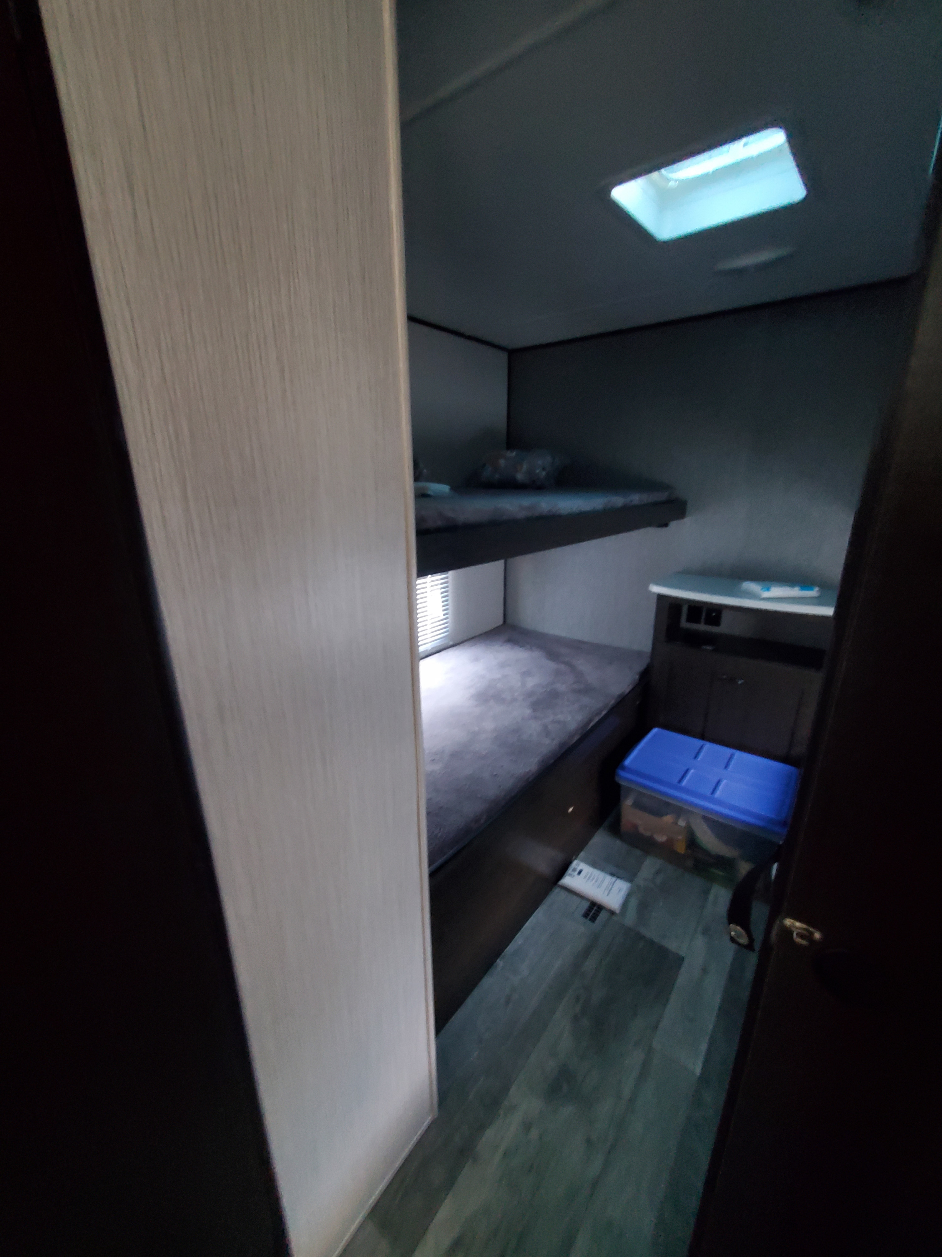 This RV rental offers a practical interior with cozy bunk beds, a window, and a storage cabinet, ideal for a compact space.. Heartland RVs Prowler 2021