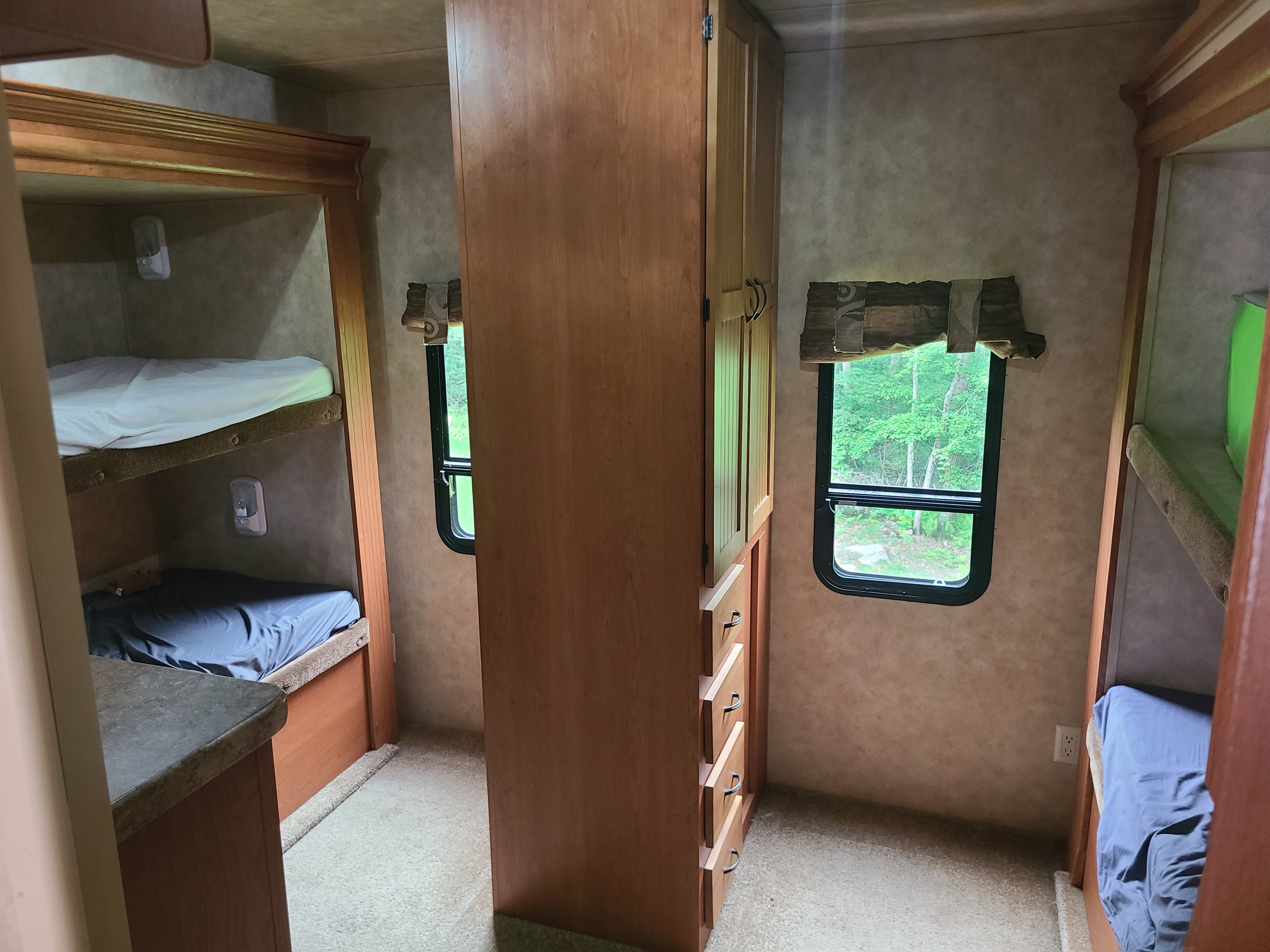 RV rental interior: bunk beds, wooden cabinet, and nature view from window. Ideal for comfortable travel.. Durango Durango Fifth Wheel 2009