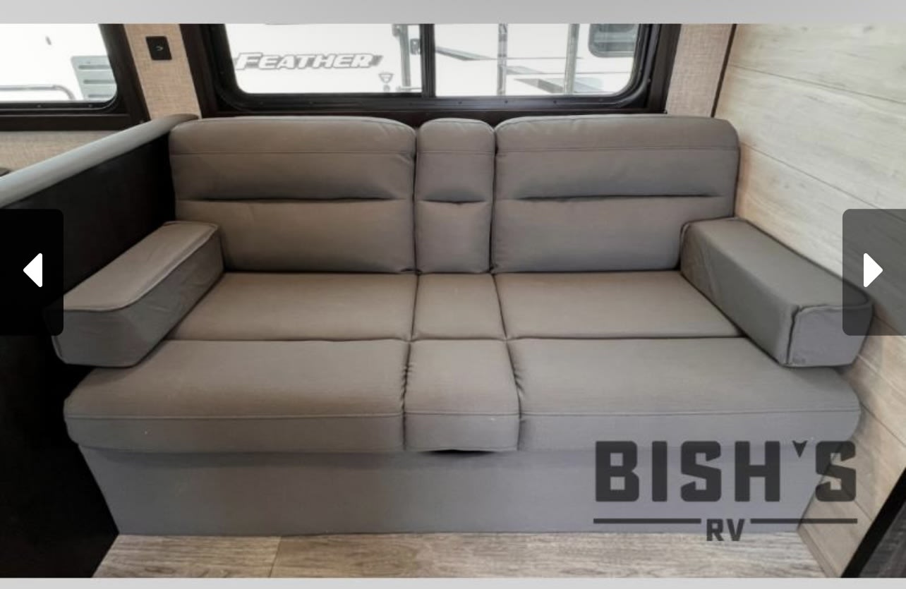 Comfortable gray RV rental sofa, perfect for seating or as a convertible bed, enhancing your RV's living space.. Jayco Jay Flight 2023