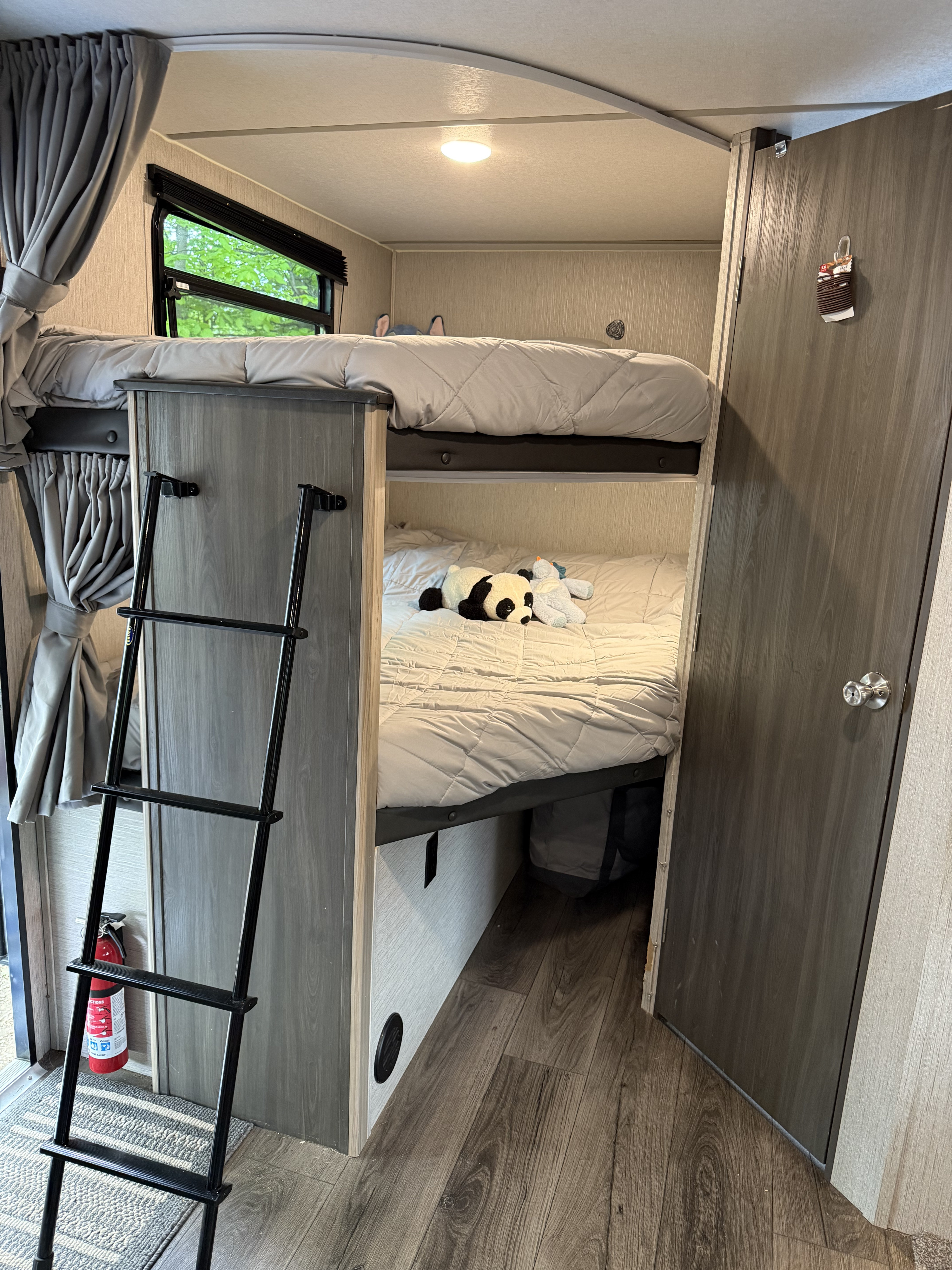 Inside an RV rental, showing cozy bunk beds with a ladder, window, and plush toys, perfect for family adventures.. Coachmen Freedom Express Select 2021