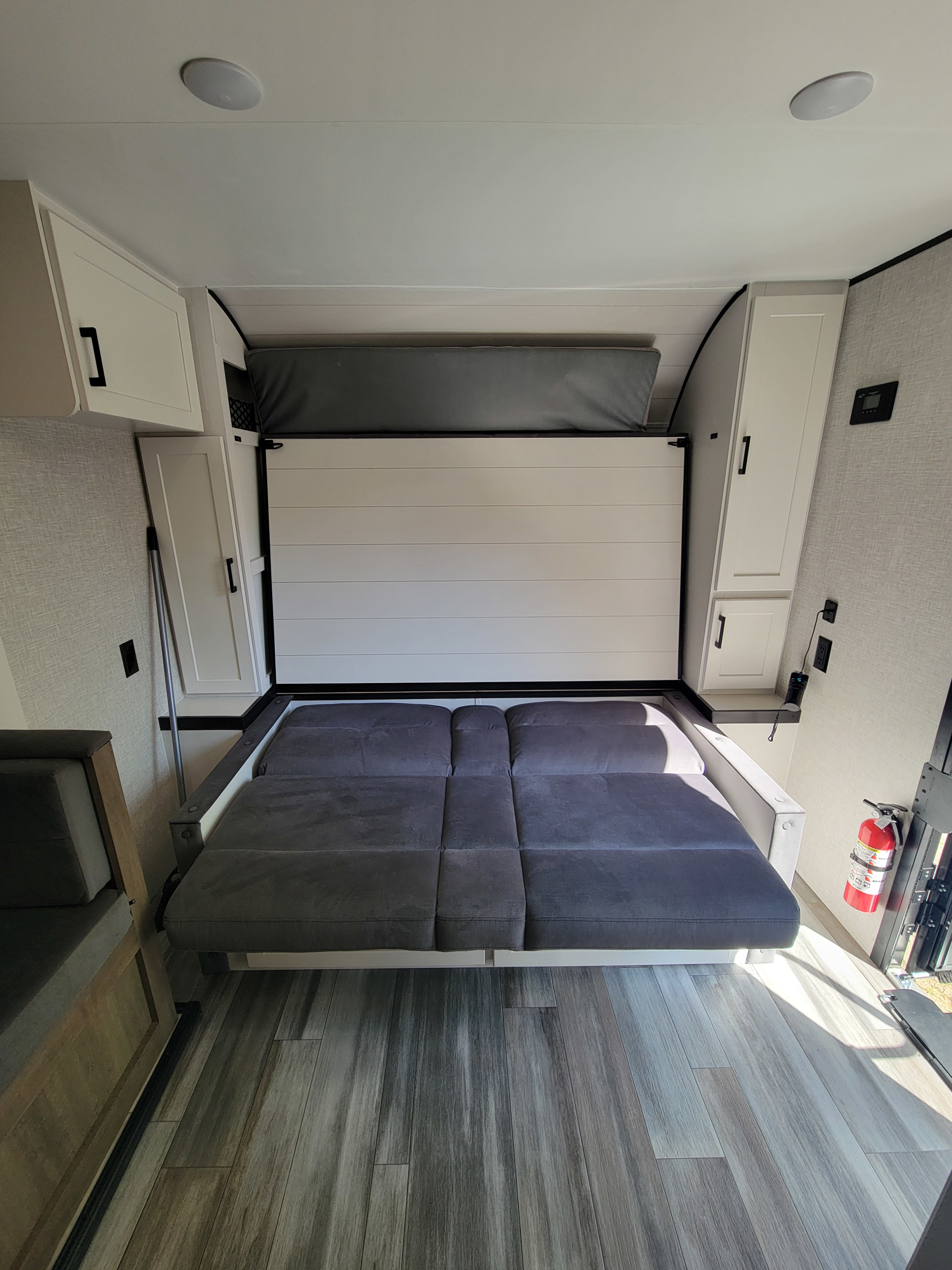 Spacious RV rental interior featuring a gray convertible bed/sofa, white storage cabinets, and light wood-look flooring.. Jayco Jay Flight SLX 197MBW Baja Edition 2025
