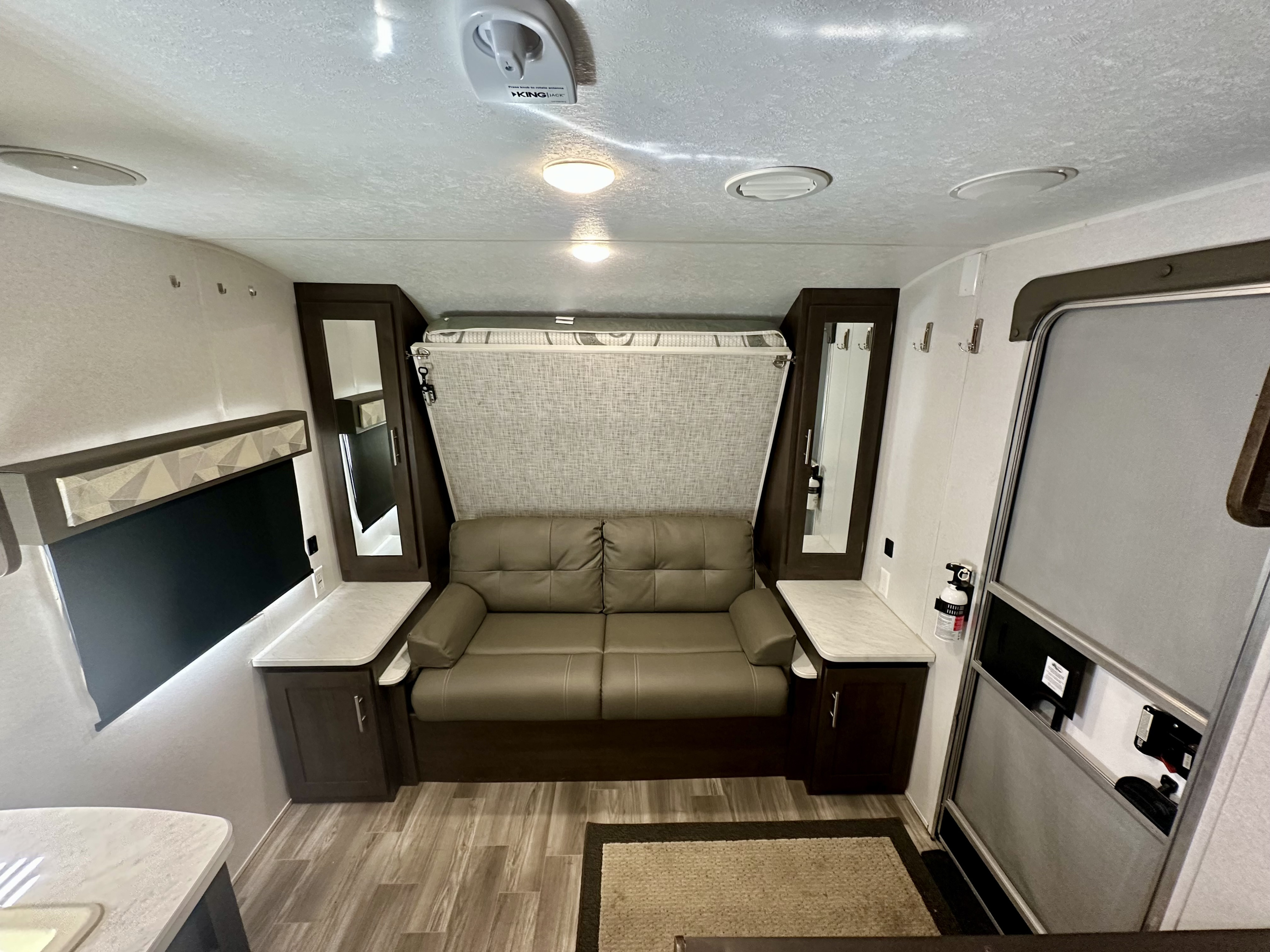 RV rental interior features a convertible sofa, fold-down bed, TV, and storage for a comfortable travel experience.. Forest River Wildwood X-Lite 2020