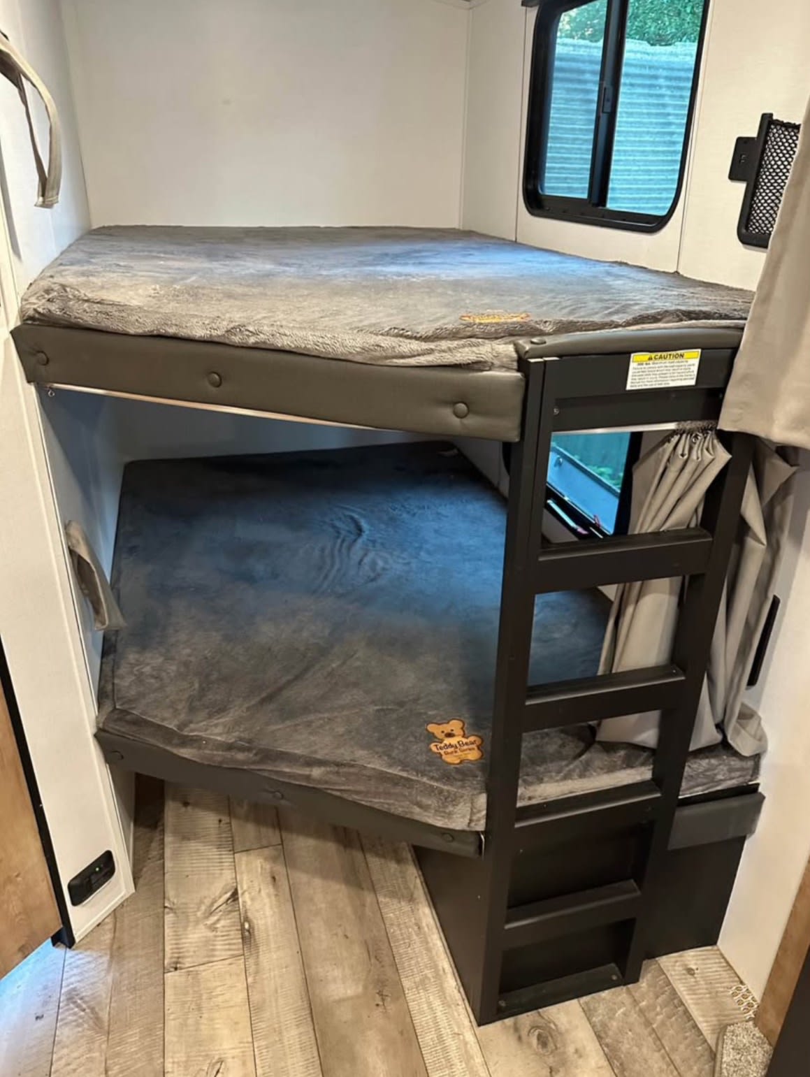 Cozy RV rental bunk beds with soft gray Teddy Bear mattresses, providing comfort for family travel.. Keystone RV Springdale 2022