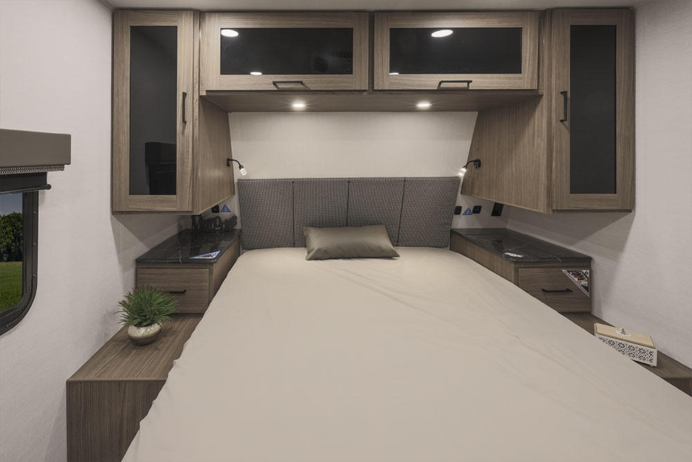 Cozy RV rental bedroom with a comfortable bed, overhead cabinets, and built-in storage. Ideal for travel comfort.. Alliance Delta 281bh 2024