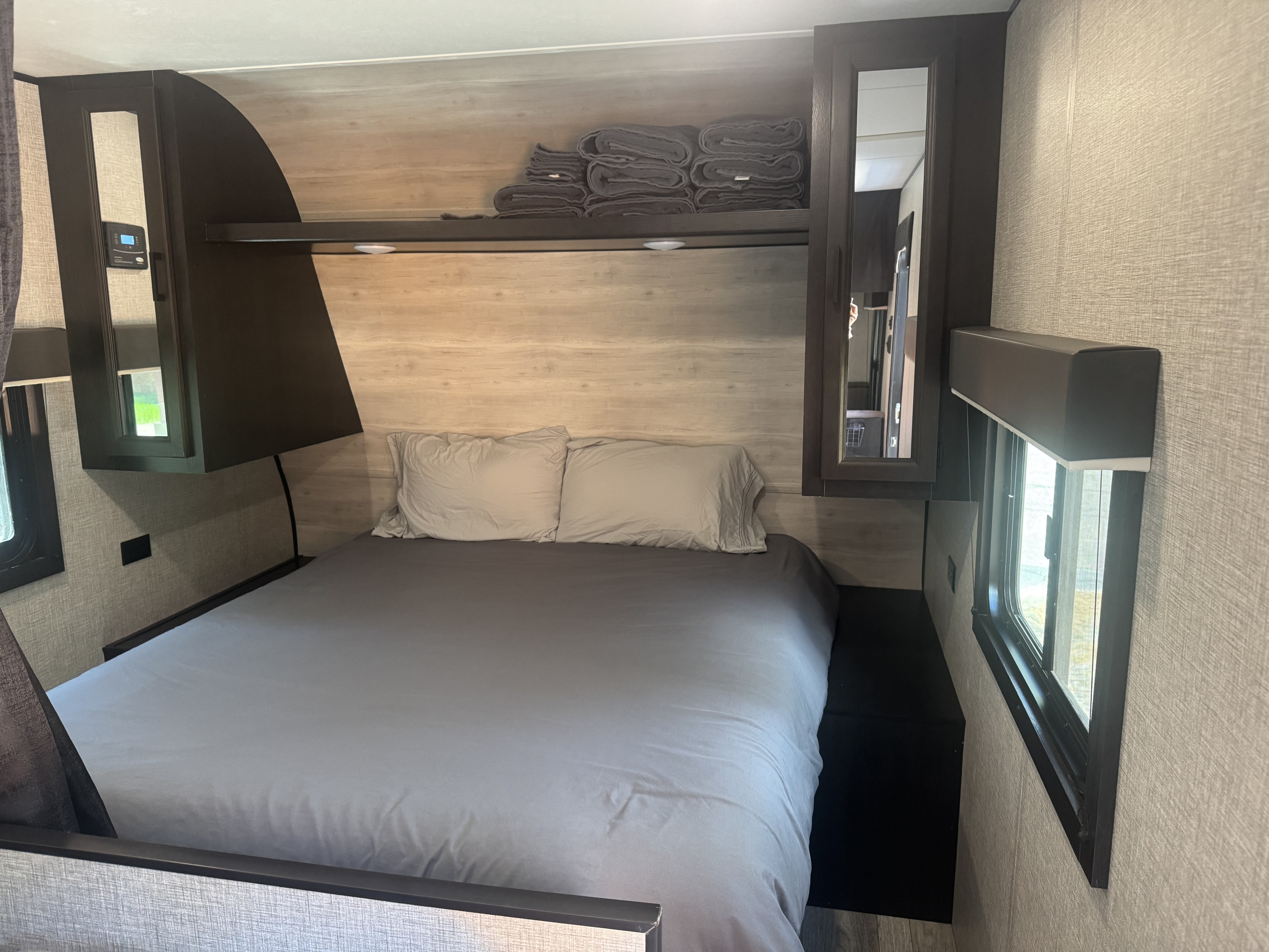 RV rental bedroom featuring a comfortable bed, storage cabinets, and natural light from windows. Ideal for travel.. Jayco Jay Flight SLX Rocky Mountain Edition 2022