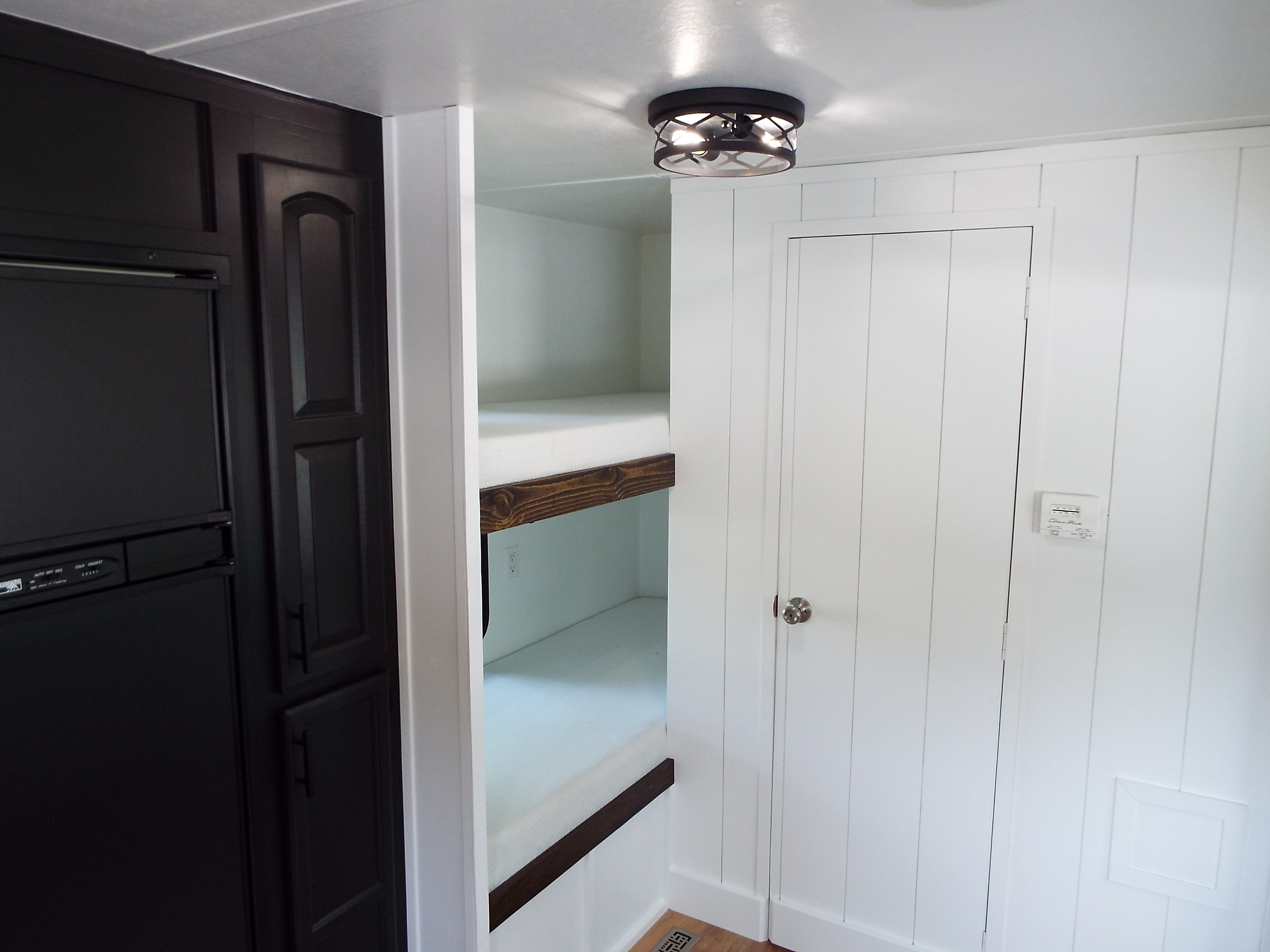 Modern RV rental interior featuring a black kitchen, white bunk beds, and a bright, functional living space with a clean design.. Jayco Jay Flight 2011