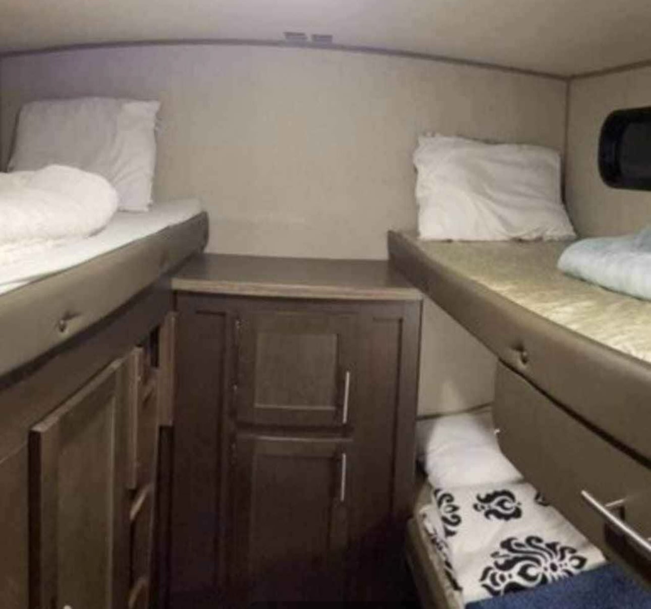 RV rental bunk beds: A cozy, compact sleeping area with multiple bunks and built-in storage in an RV interior.. Forest River Cherokee Grey Wolf 2016